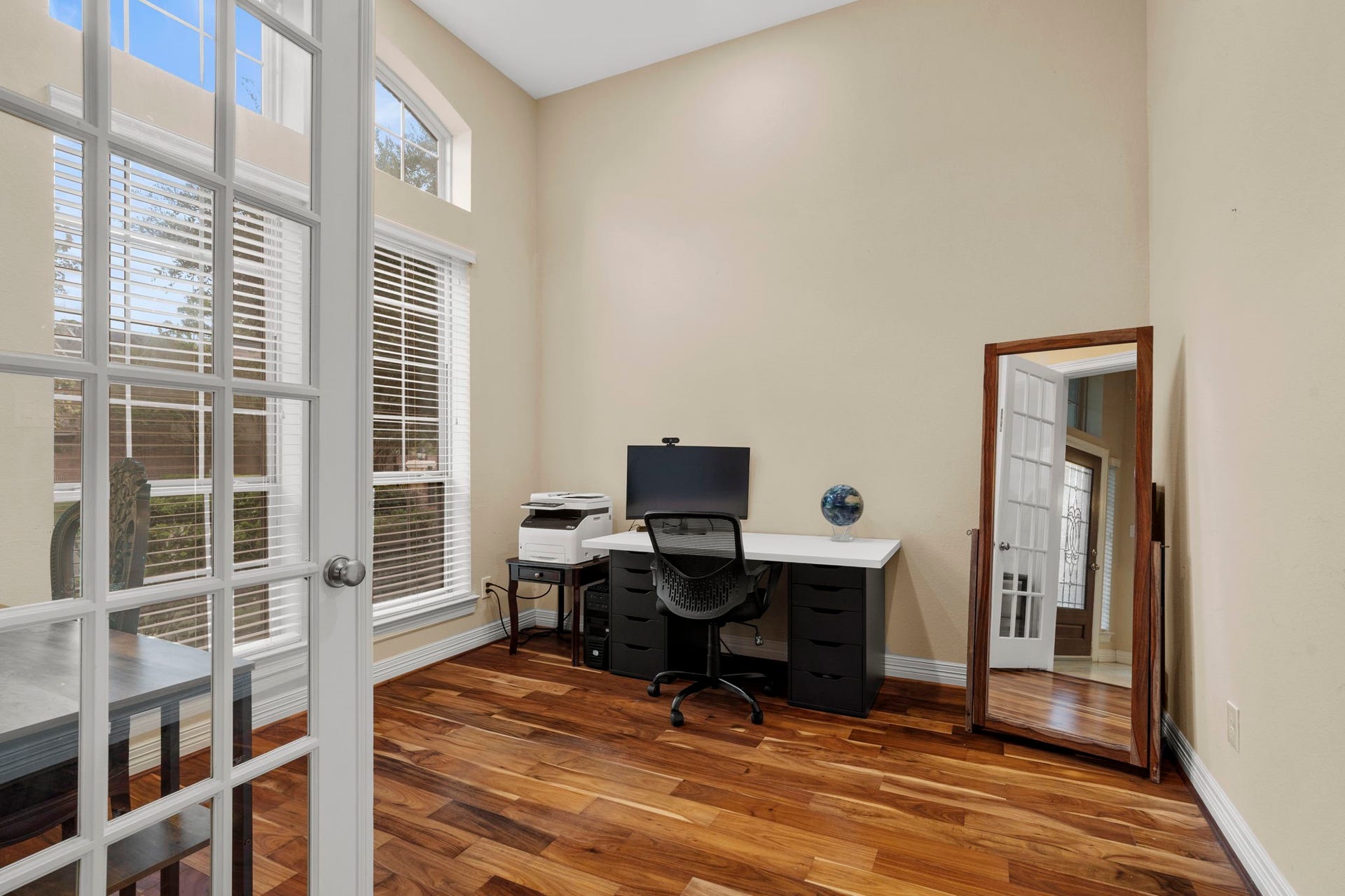 5515 Mangrove Creek Lane, Sugar Land, TX 77479 French doors open to a private home office at the front of the home, featuring high ceilings and a wall of windows.