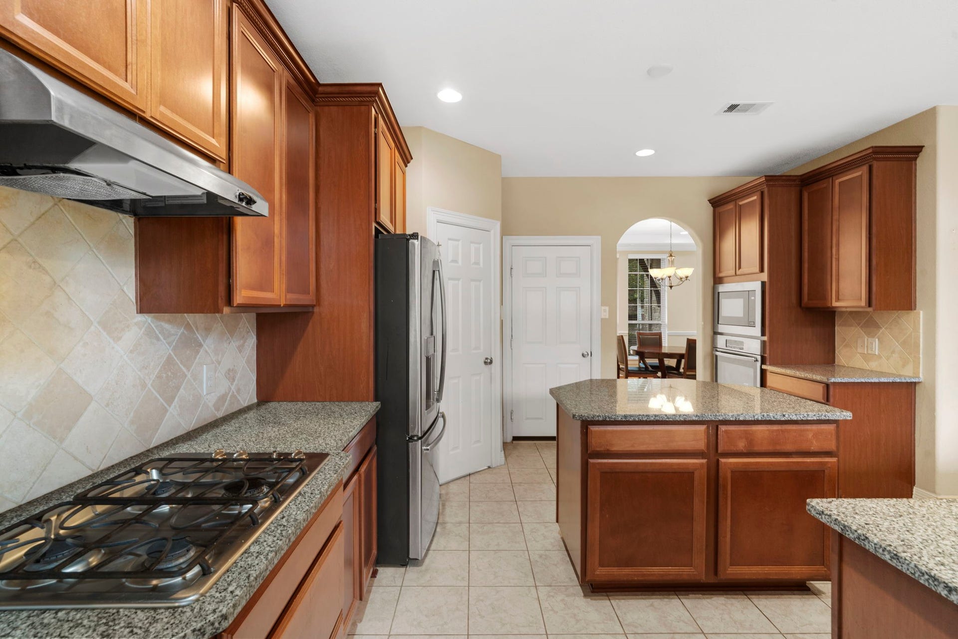 5515 Mangrove Creek Lane, Sugar Land, TX 77479 Gas cooktop, electric wall oven, and built-in microwave offer versatile cooking options.