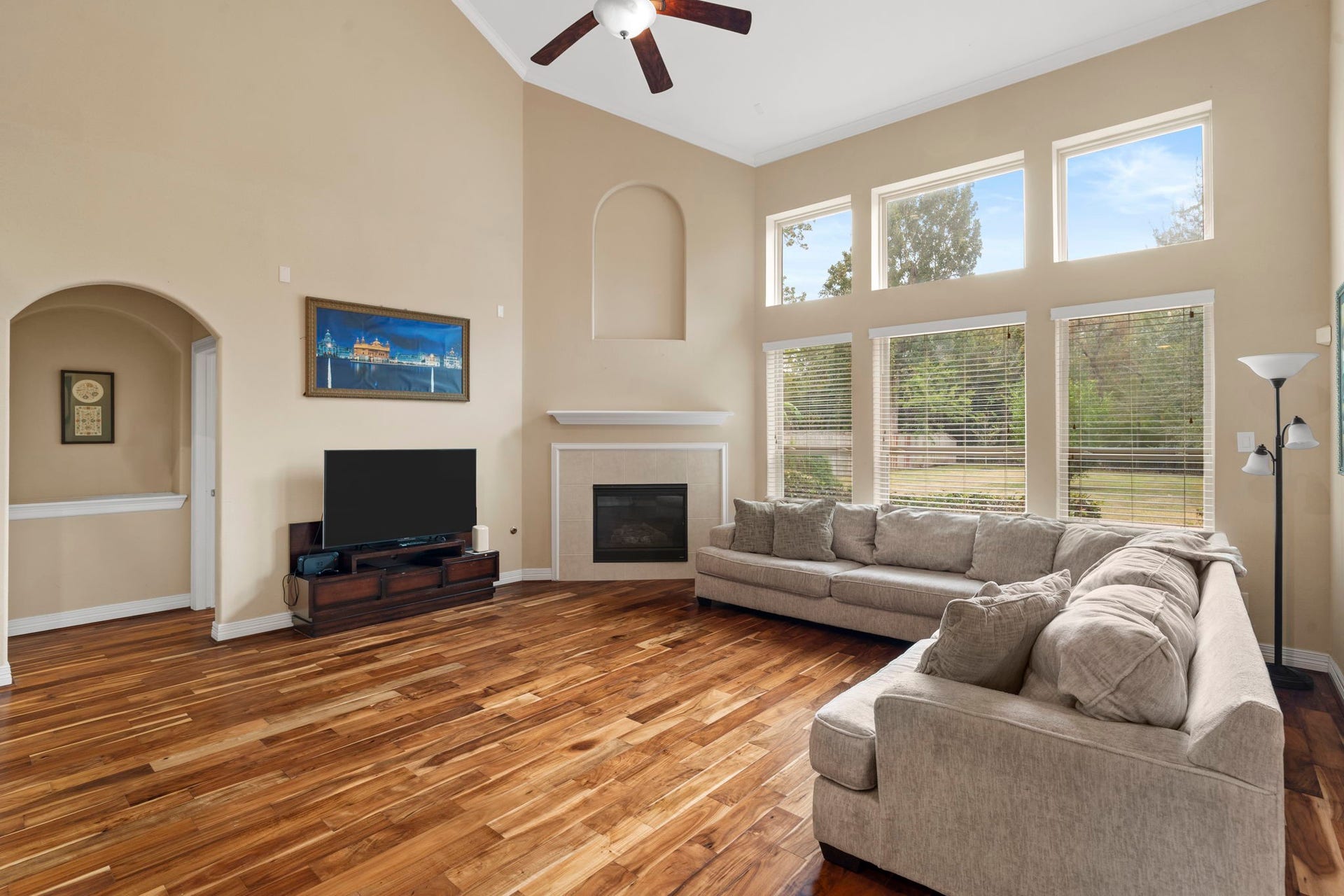 5515 Mangrove Creek Lane, Sugar Land, TX 77479 Light and airy living room featuring soaring two-story ceilings and floor-to-ceiling windows overlooking the private backyard.