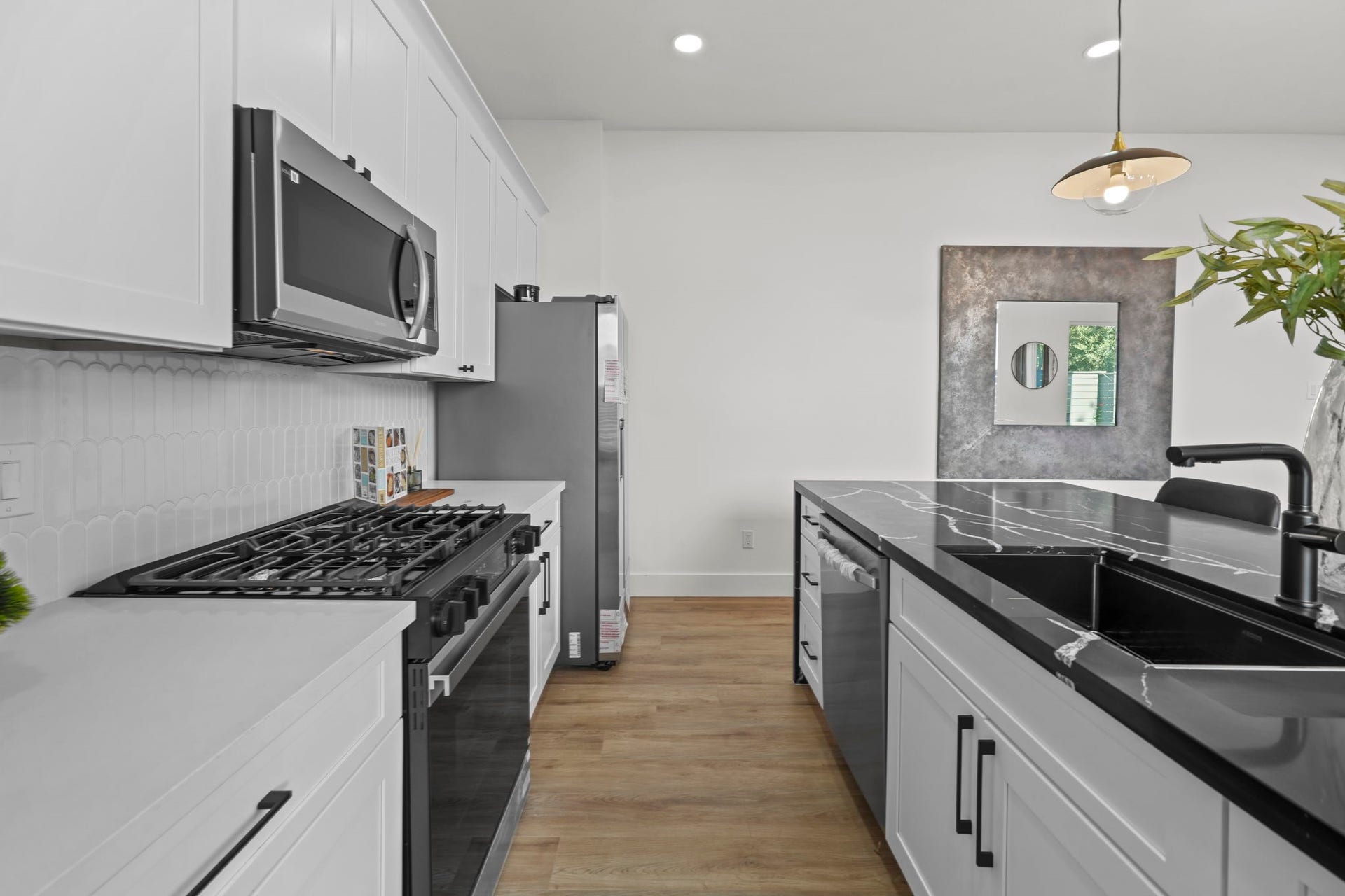 The kitchen is fully equipped with stainless steel appliances, a deep sink, and gas oven and range.