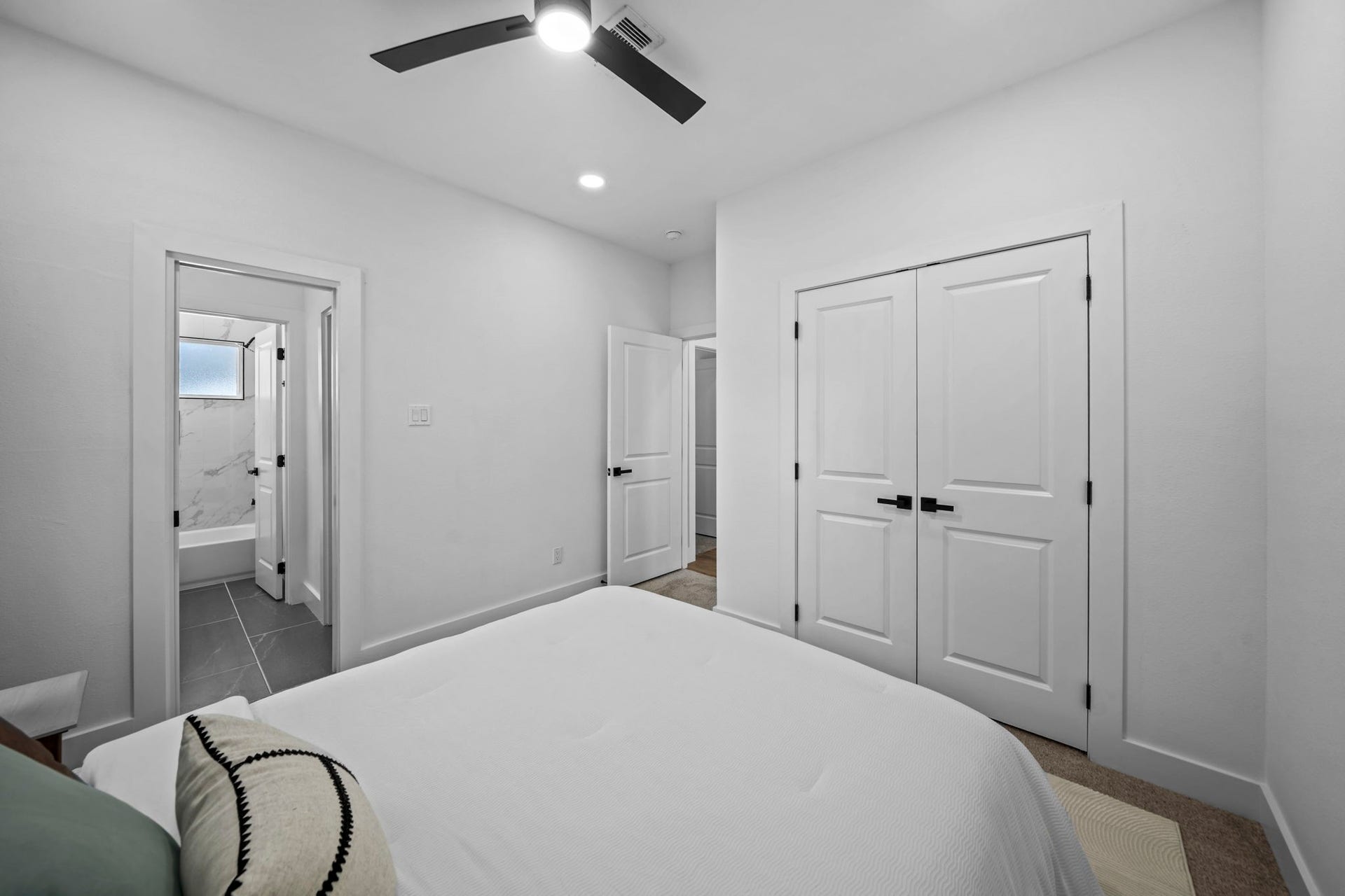 Another angle of the second bedroom showing the closet and entrance to the shared secondary bathroom.