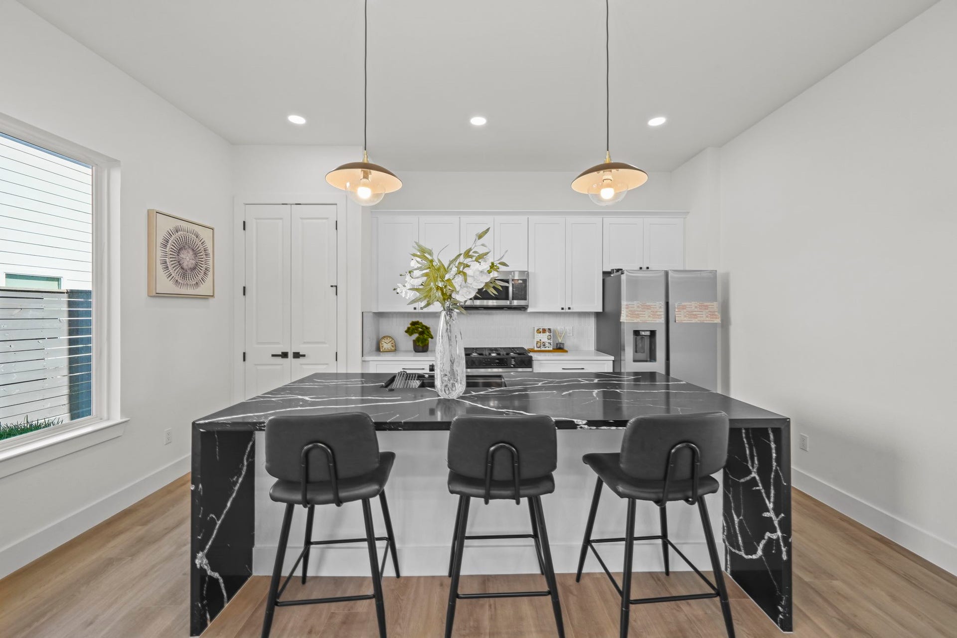 This modern home boasts an elevated kitchen, complete with a large island with a breakfast bar and stainless steel appliances.