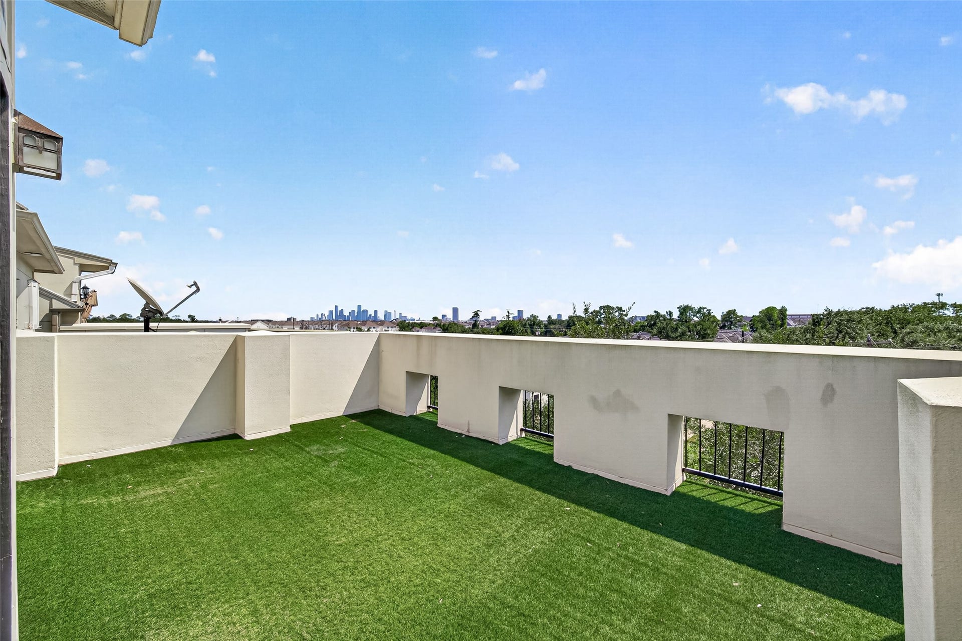 6610 Toledo Street, Houston, TX 77008 Expansive rooftop terrace with lush green turf offers stunning city skyline views, perfect for outdoor relaxation and entertainment.