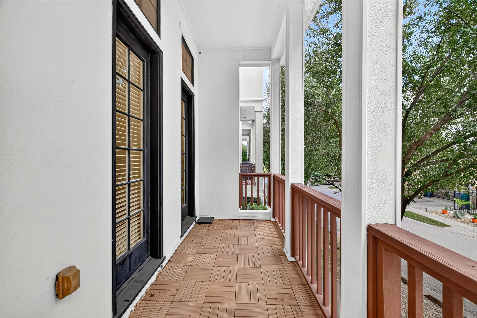 6610 Toledo Street, Houston, TX 77008 Charming covered balcony with classic French doors, offering a serene outdoor space with lush tree views.