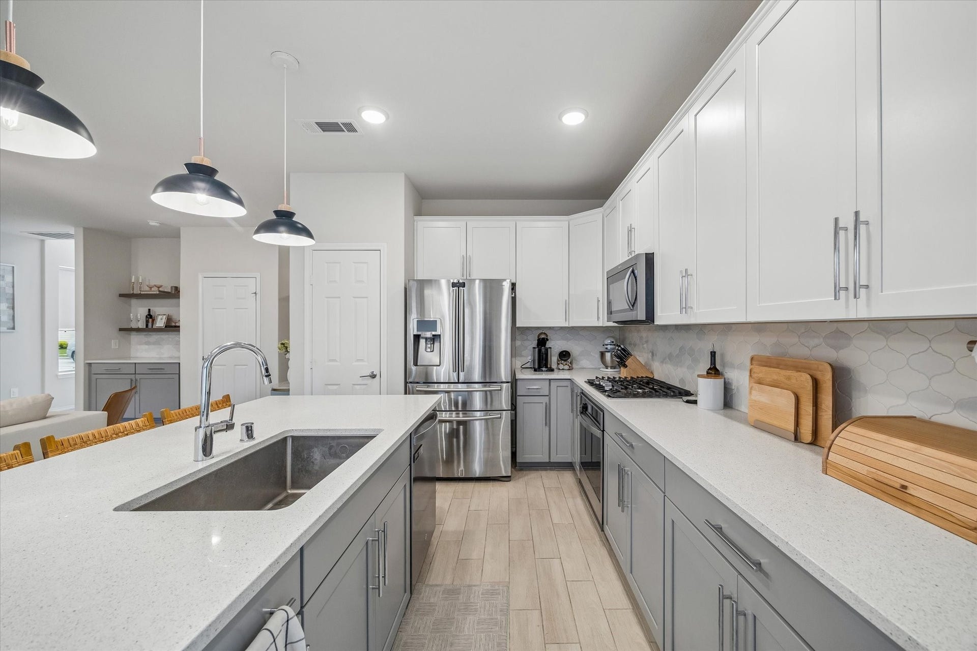 Stainless steel appliances, shaker-style cabinetry, and stylish finishes elevate the heart of the home.