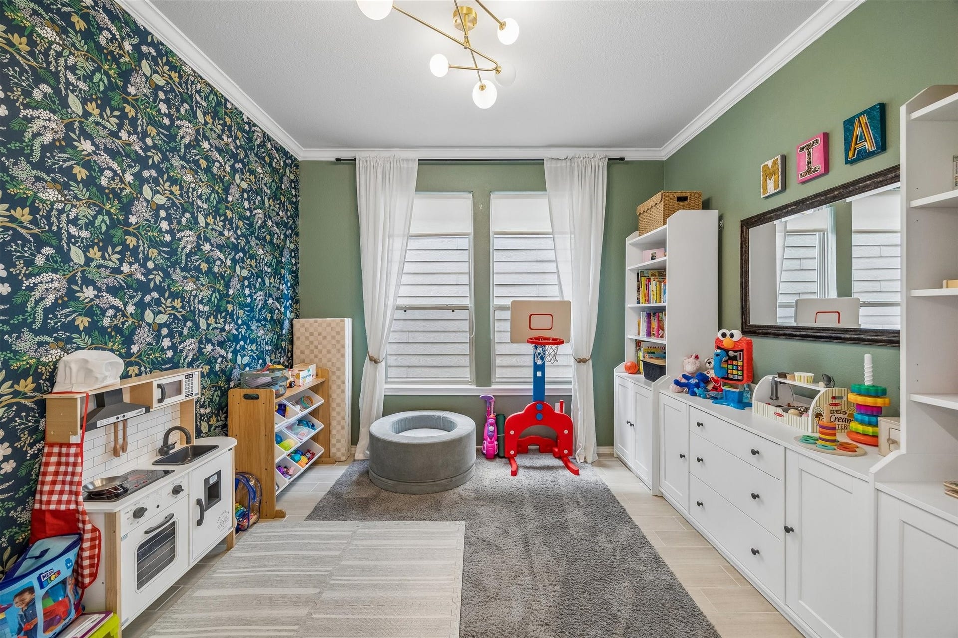 Stylish first floor flex space featuring custom accent wall, built-in storage, and plenty of room for toys, activities or home office.
