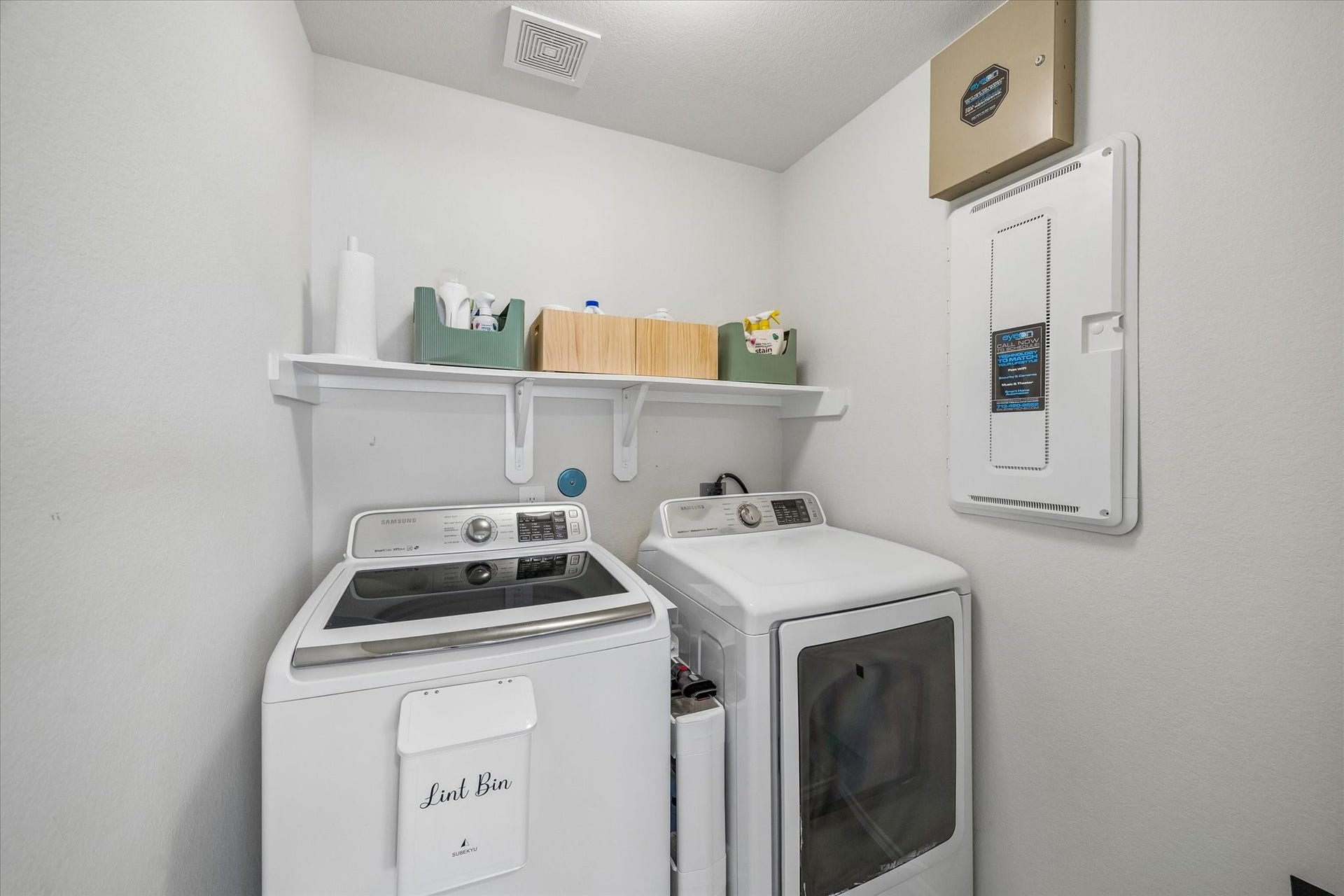 Dedicated laundry room with upper shelving for added storage and organization.