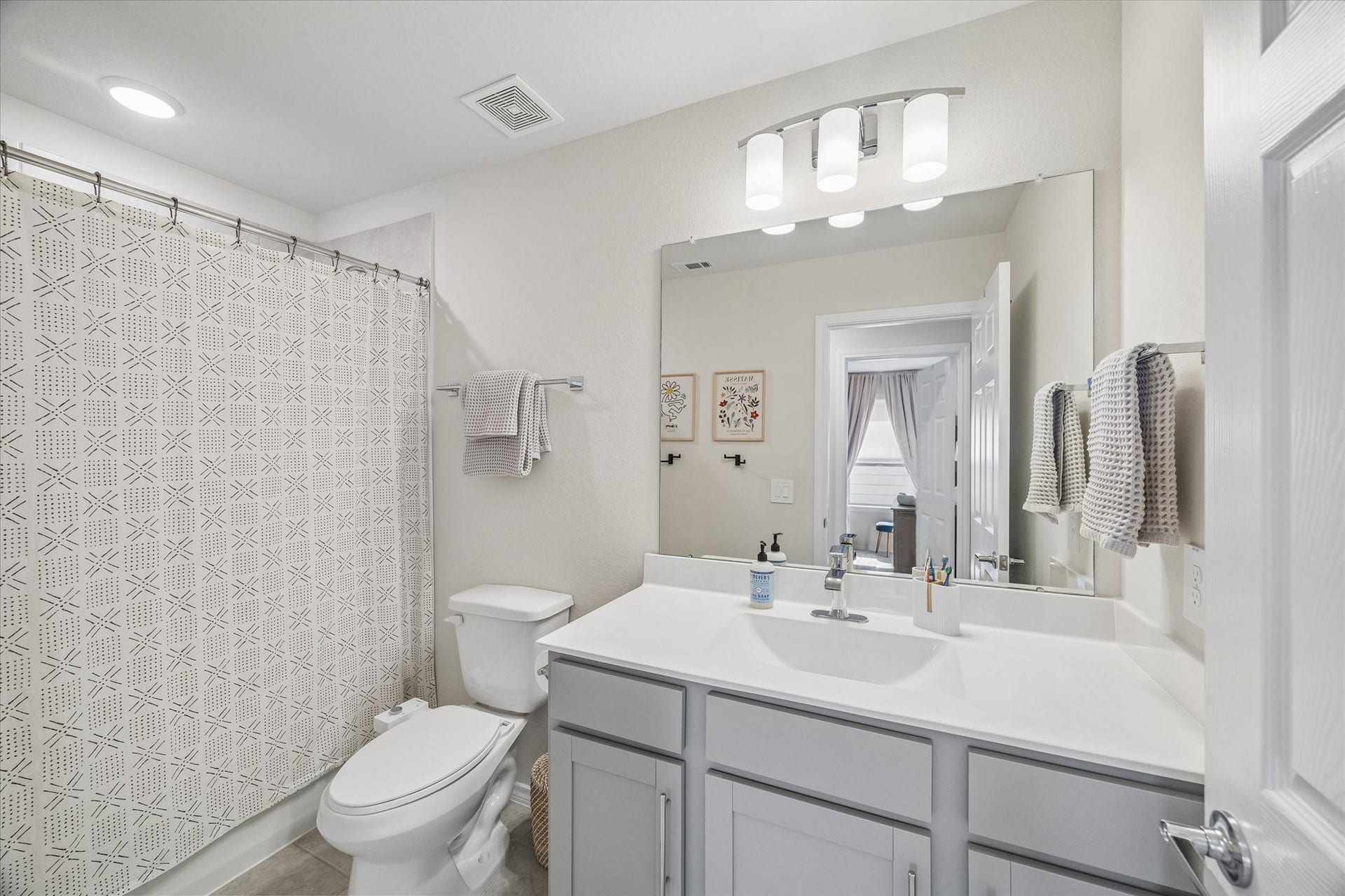 Bright full bathroom with oversized vanity, modern finishes, and a tub/shower combination.