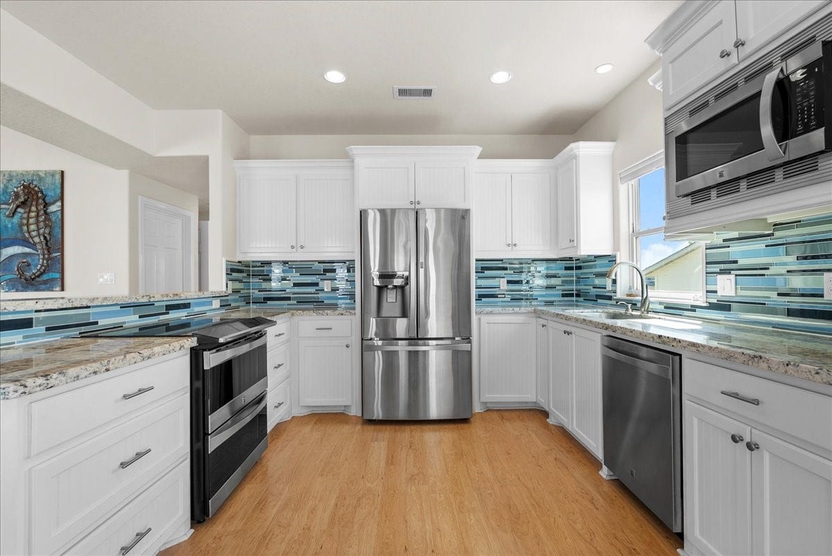 314 Windward Way, Tiki Island, TX 77554 he kitchen impresses with designer backsplash, abundant cabinetry, stainless steel appliances, breakfast bar, and expansive granite countertops.