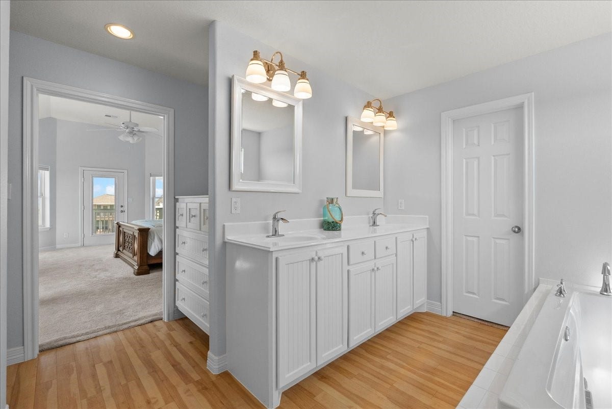 314 Windward Way, Tiki Island, TX 77554 Spa-inspired en-suite with soaking tub, walk-in shower, dual sinks, and walk-in closet.