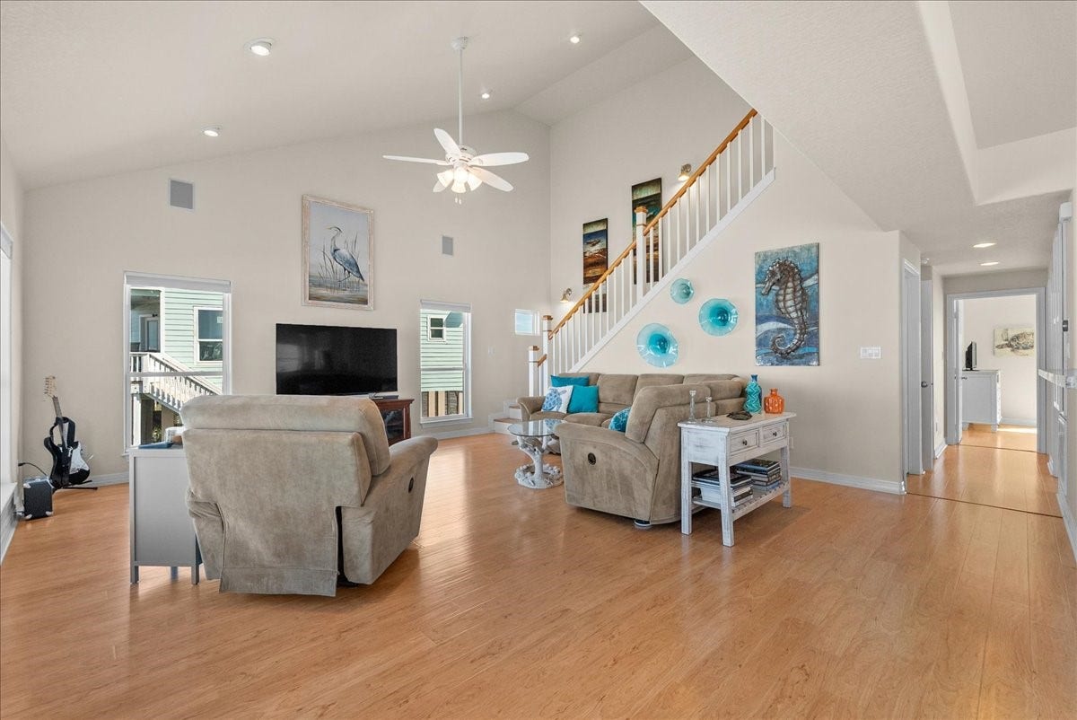 314 Windward Way, Tiki Island, TX 77554 The spacious living room features soaring ceilings, an abundance of natural light, and expansive windows showcasing beautiful waterfront views.