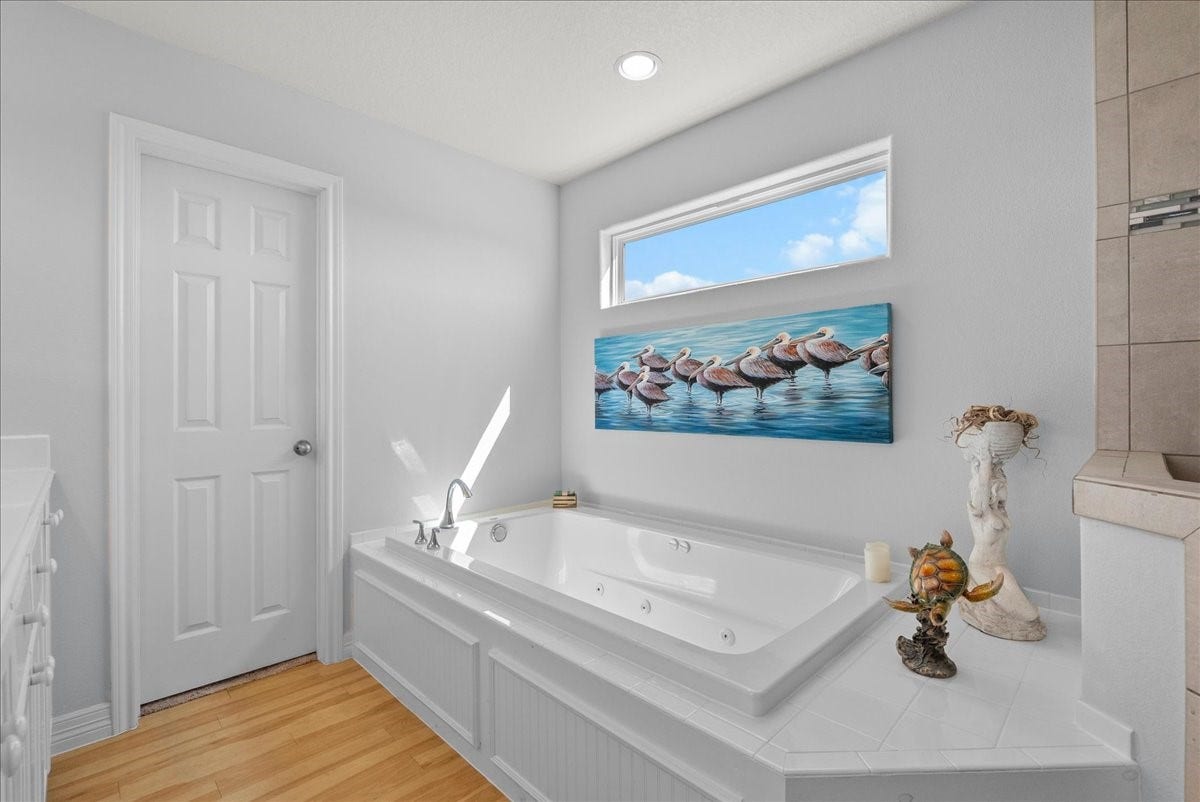 314 Windward Way, Tiki Island, TX 77554 Spa-inspired en-suite with soaking tub, walk-in shower, dual sinks, and walk-in closet.