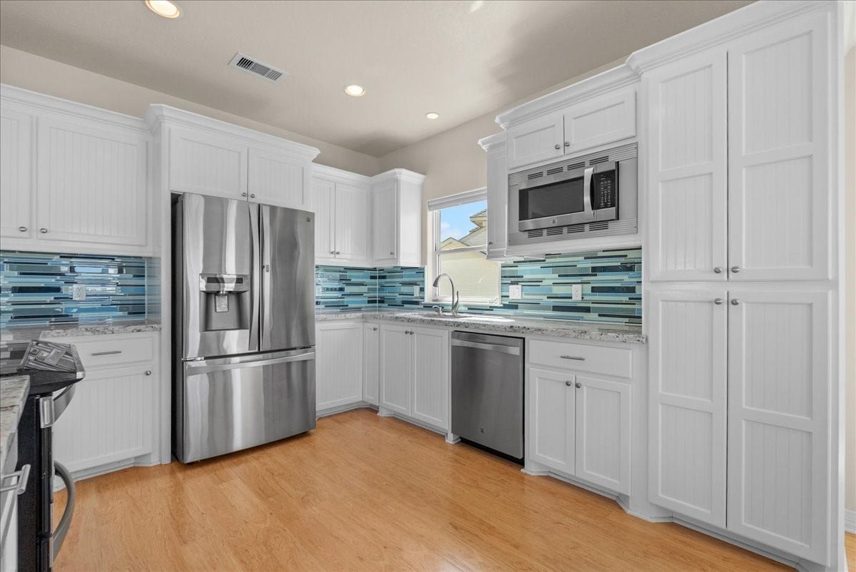 314 Windward Way, Tiki Island, TX 77554 he kitchen impresses with designer backsplash, abundant cabinetry, stainless steel appliances, breakfast bar, and expansive granite countertops.