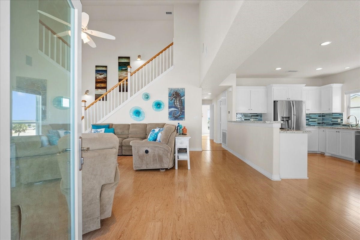 314 Windward Way, Tiki Island, TX 77554 Enter to soaring ceilings and open-concept living with an abundance of windows showcasing beautiful waterfront views.