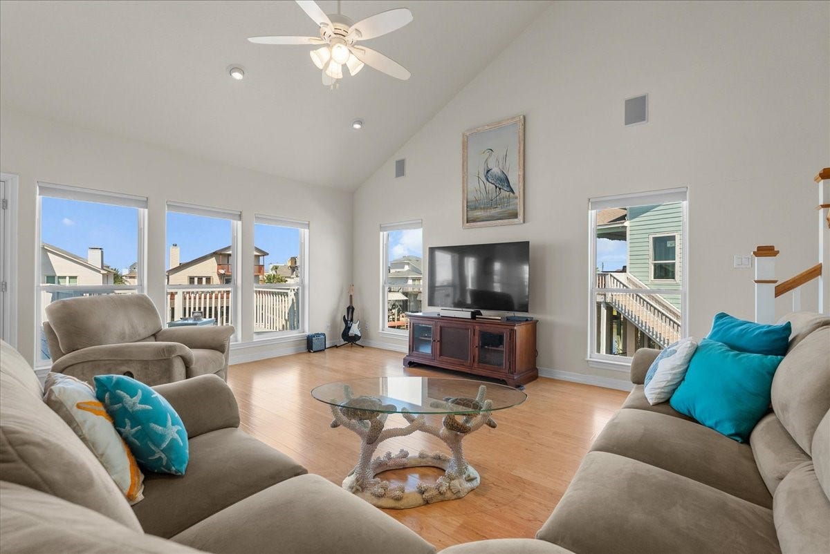 314 Windward Way, Tiki Island, TX 77554 The spacious living room features soaring ceilings, an abundance of natural light, and expansive windows showcasing beautiful waterfront views.