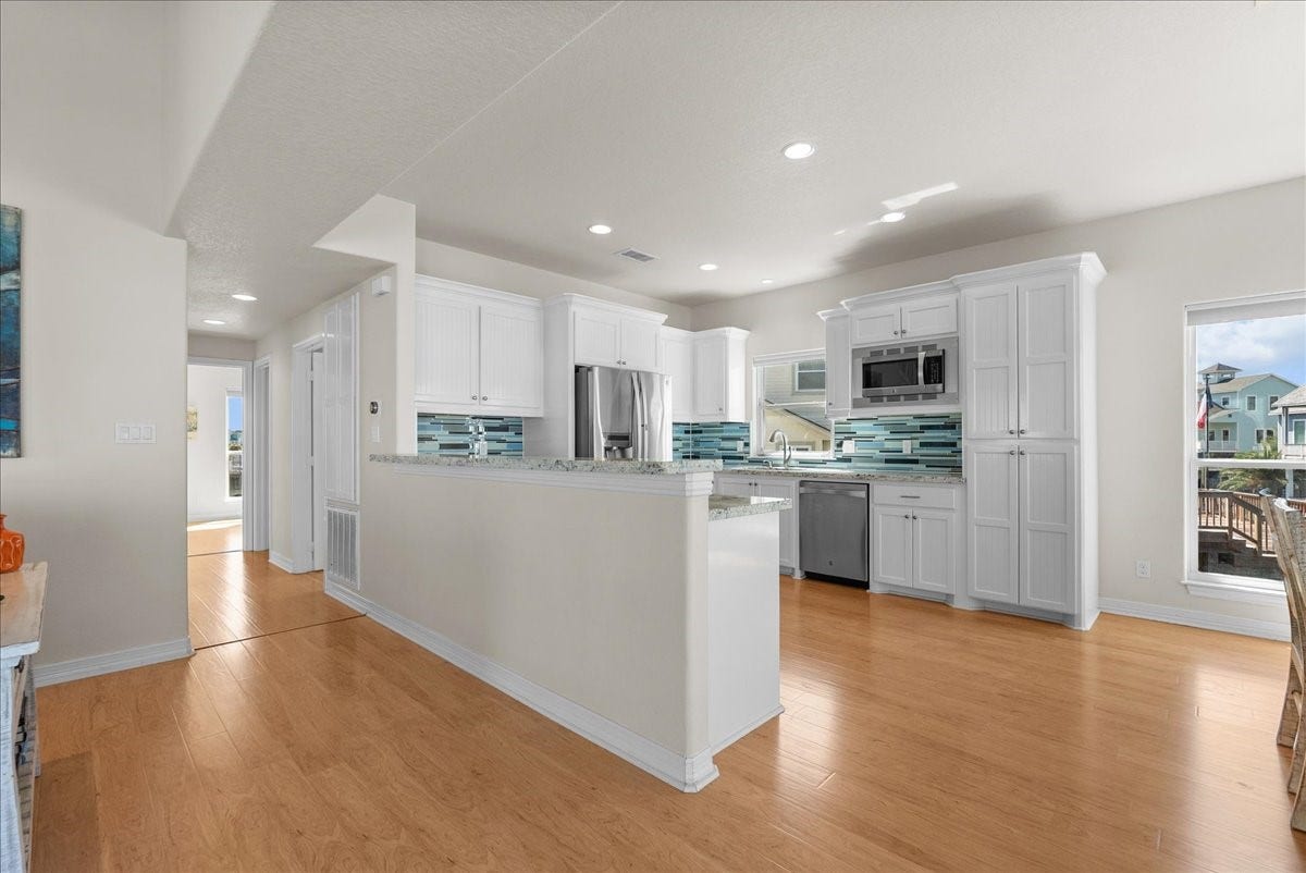 314 Windward Way, Tiki Island, TX 77554 he kitchen impresses with designer backsplash, abundant cabinetry, stainless steel appliances, breakfast bar, and expansive granite countertops.