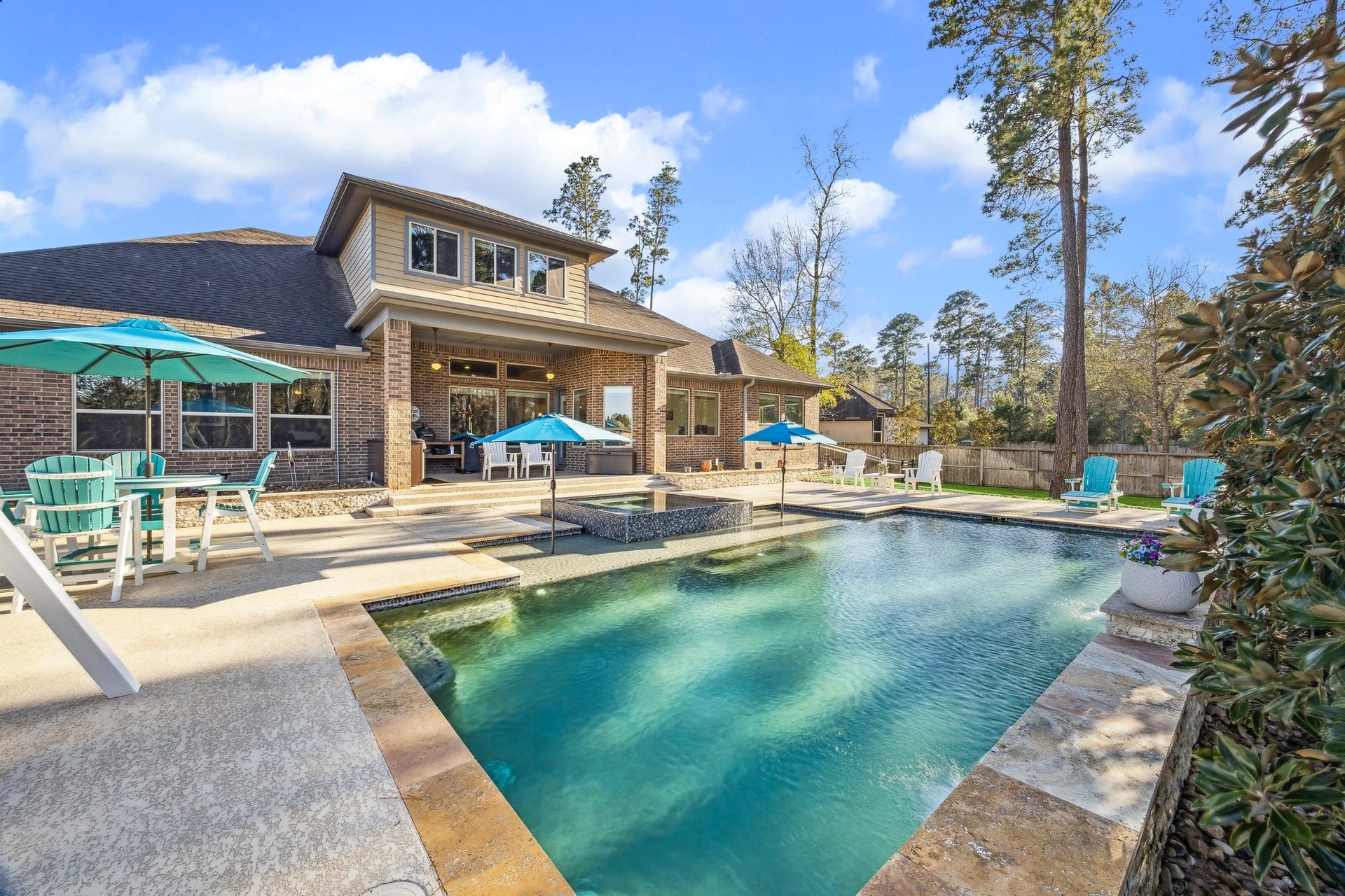 THE SPARKLING HEATED POOL & SPA LEADING TO THE COVERED PATIO & STELLAR BUILT-IN OUTDOOR KITCHEN- Note the limestone pool coping & the expansive textured concrete decking.