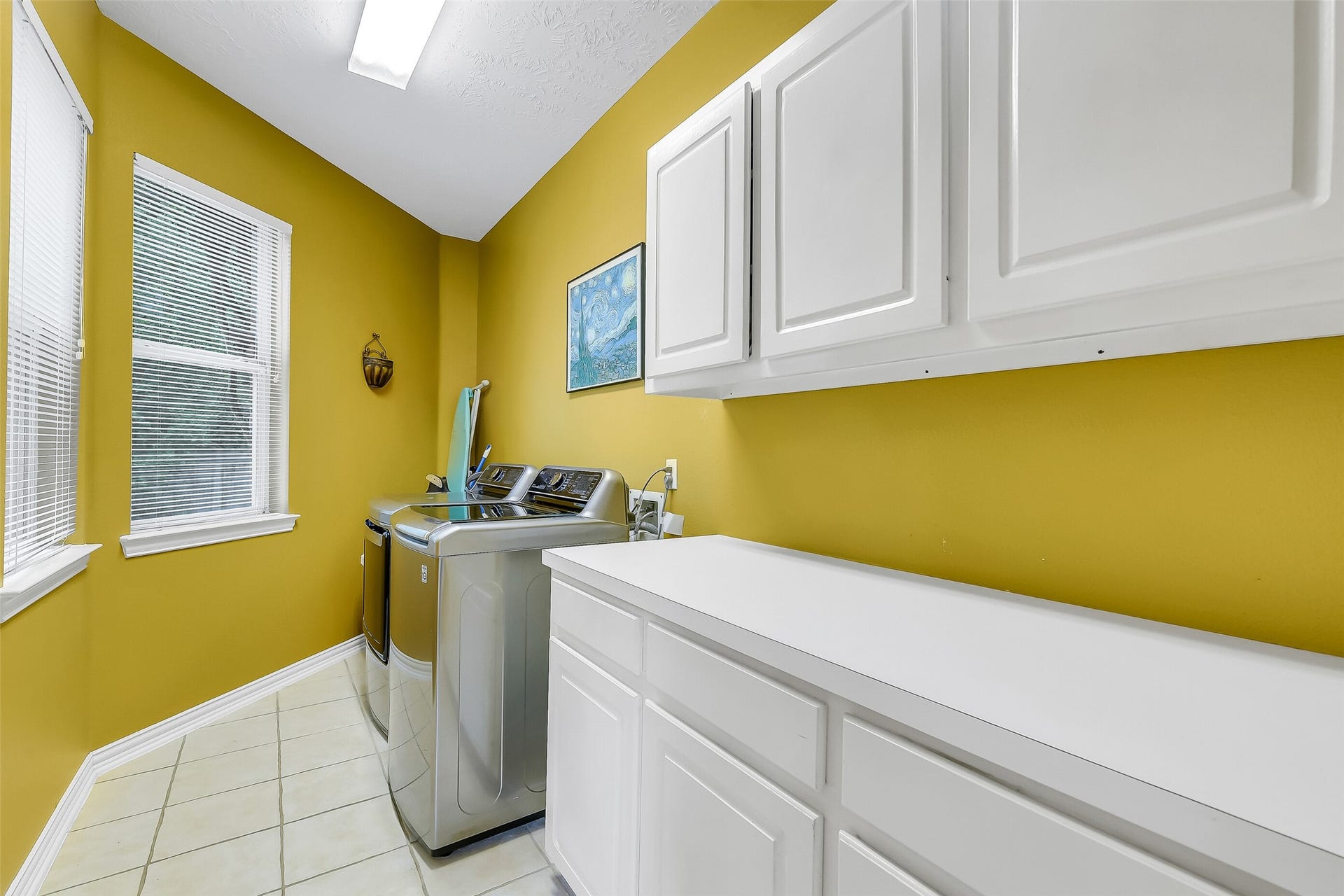 7 Larkspur Trail, The Woodlands, TX 77382 Bright and functional laundry room featuring ample cabinetry, modern appliances, and large windows for natural light.