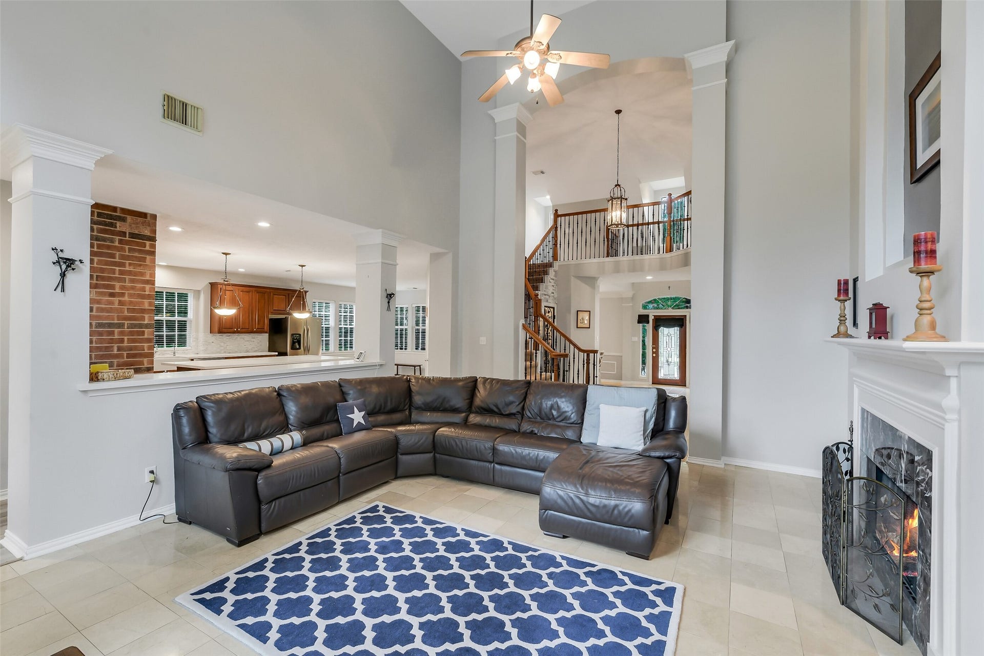 7 Larkspur Trail, The Woodlands, TX 77382 Spacious living room with vaulted ceilings, a cozy fireplace, and an open layout leading to a modern kitchen.