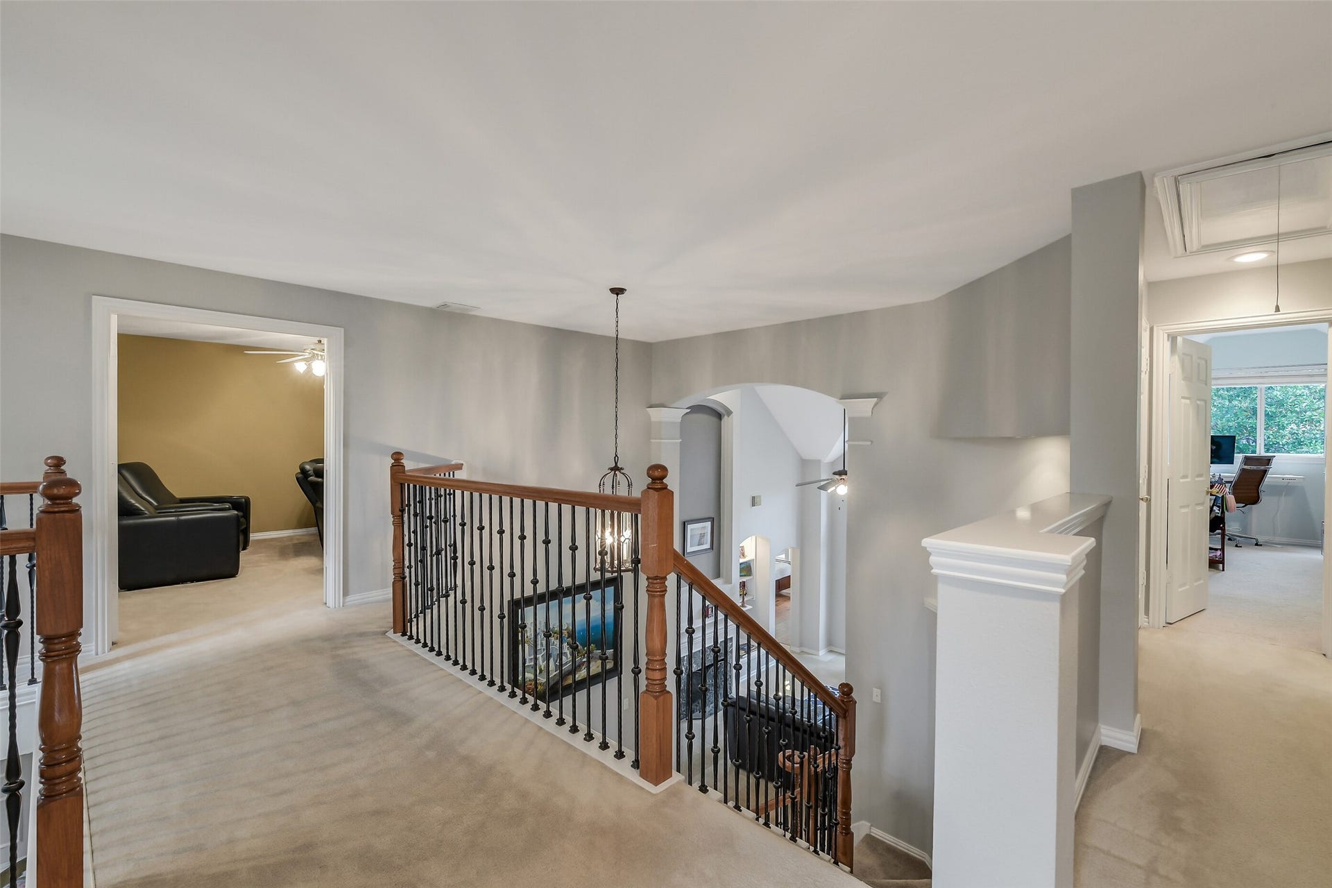 7 Larkspur Trail, The Woodlands, TX 77382 Spacious upstairs landing with elegant wood and iron railing, leading to versatile rooms perfect for a home office or entertainment.