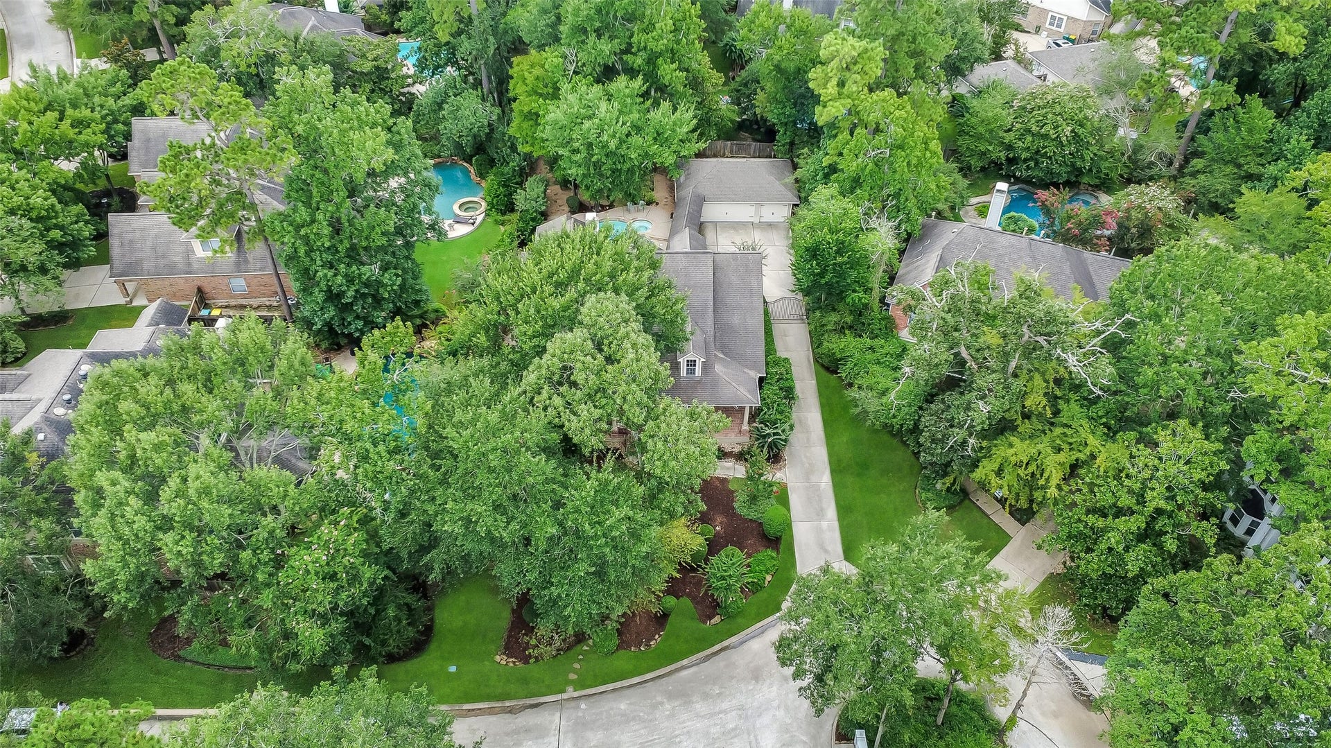 7 Larkspur Trail, The Woodlands, TX 77382 Nestled in a lush, green neighborhood, this charming home features a spacious driveway and is surrounded by mature trees, offering privacy and tranquility. The backyard includes a sparkling pool, perfect for relaxing or entertaining.