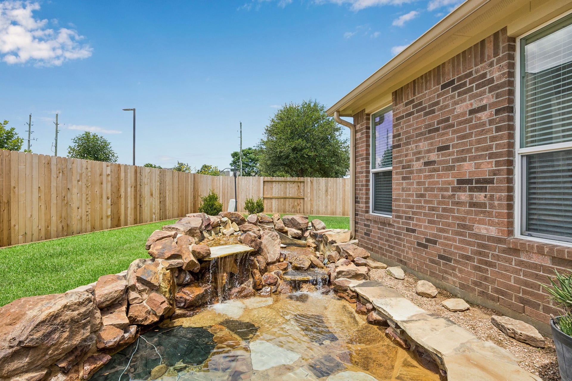 26251 Caper Meadow Lane, Katy, TX 77494 The pond is located directly behind the house and there is plenty of green space on one side and a huge yard on the other side the house.