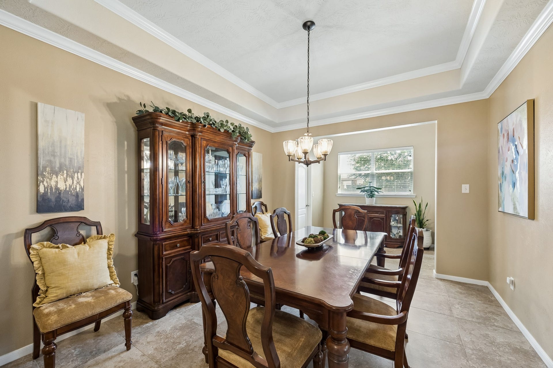26251 Caper Meadow Lane, Katy, TX 77494 As you walk further down the hallway is the Formal Dining Room with its own alcove to place a serving buffet with a window over this area. The room continues with the neutral tile floor and the room has plenty of room for a large table and china cabinet. There is another tray ceiling with crown molding and direct access to the kitchen on one side and the laundry room on the other side.