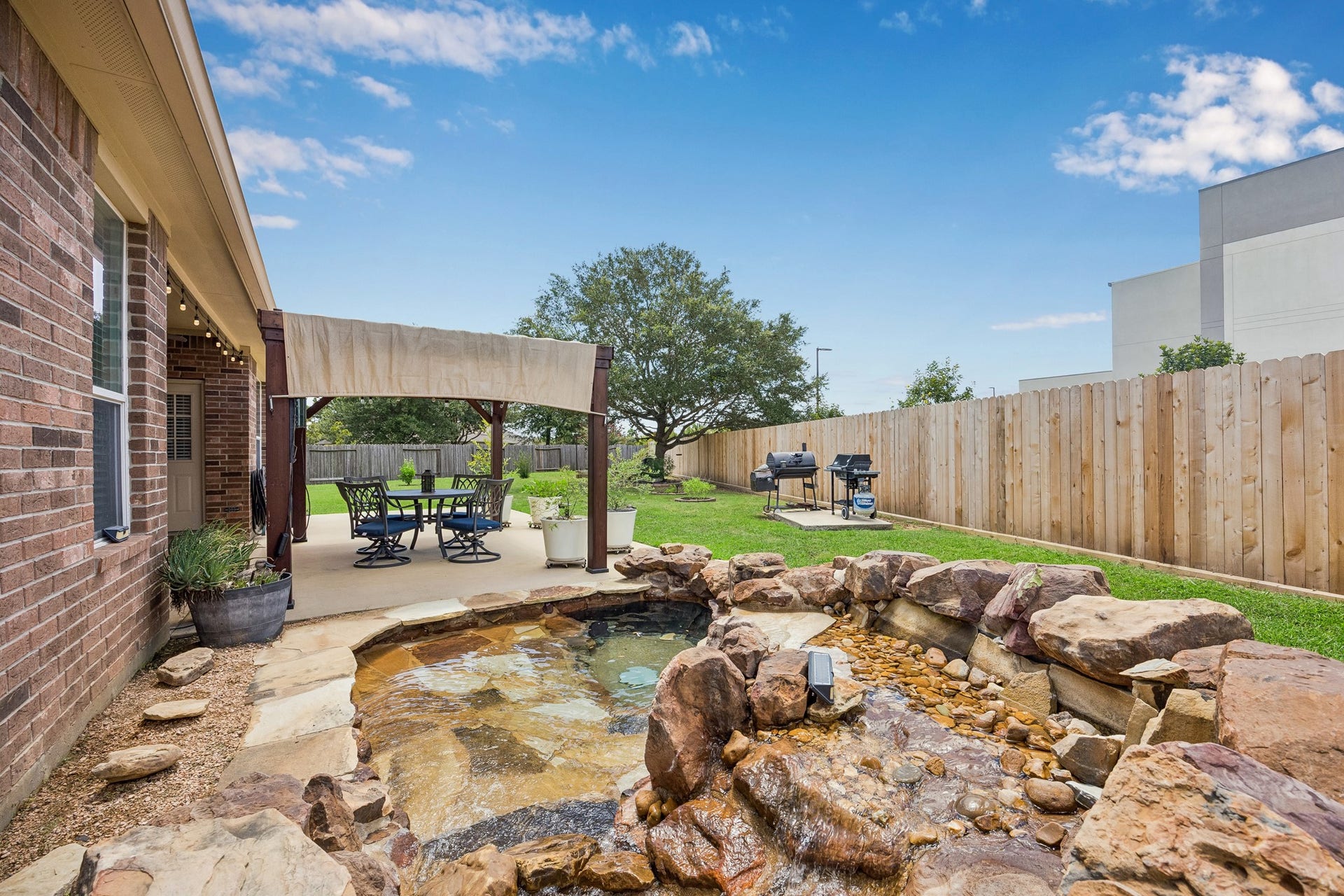 26251 Caper Meadow Lane, Katy, TX 77494 What a fun place to relax is the pond with rock waterfaill.
