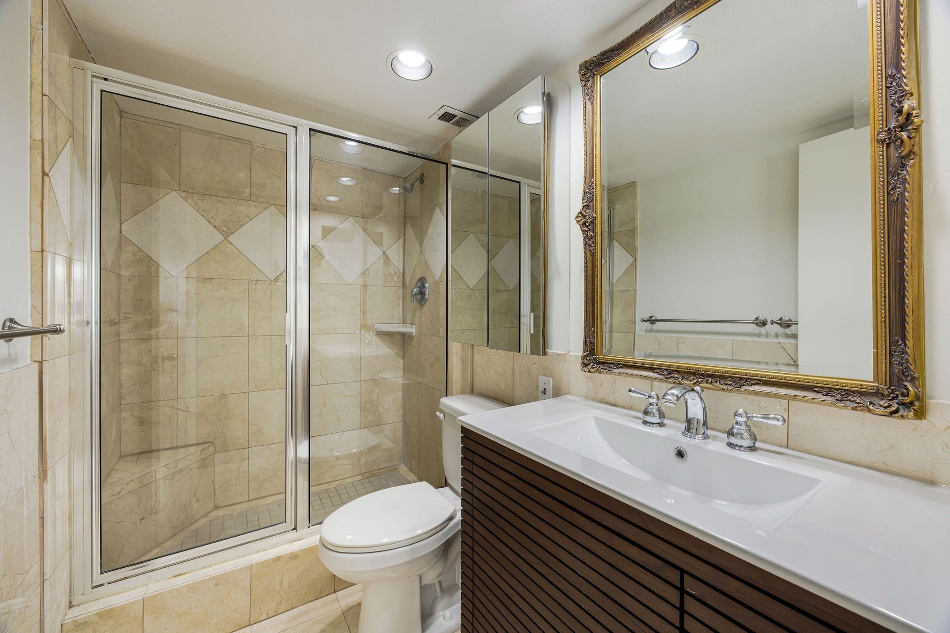 3600 Montrose Boulevard, #501, Houston, TX 77006 Elegant ensuite bathroom featuring a spacious glass-enclosed shower with stylish tile accents, a sleek modern vanity, and a large ornate mirror for a touch of luxury.