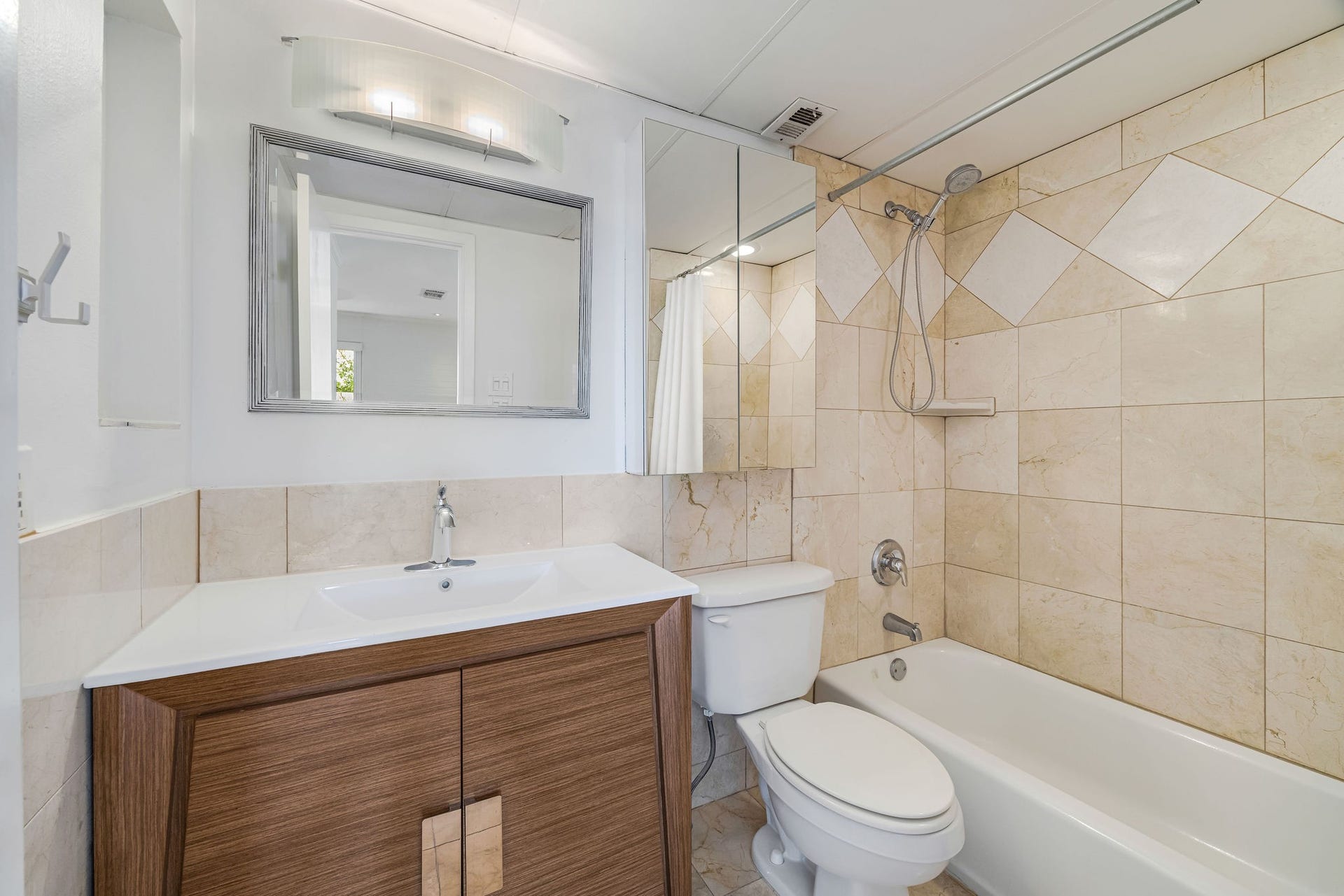 3600 Montrose Boulevard, #501, Houston, TX 77006 Modern bathroom featuring sleek tile work, a stylish vanity with a large mirror, and a combined shower and bathtub for a contemporary feel.