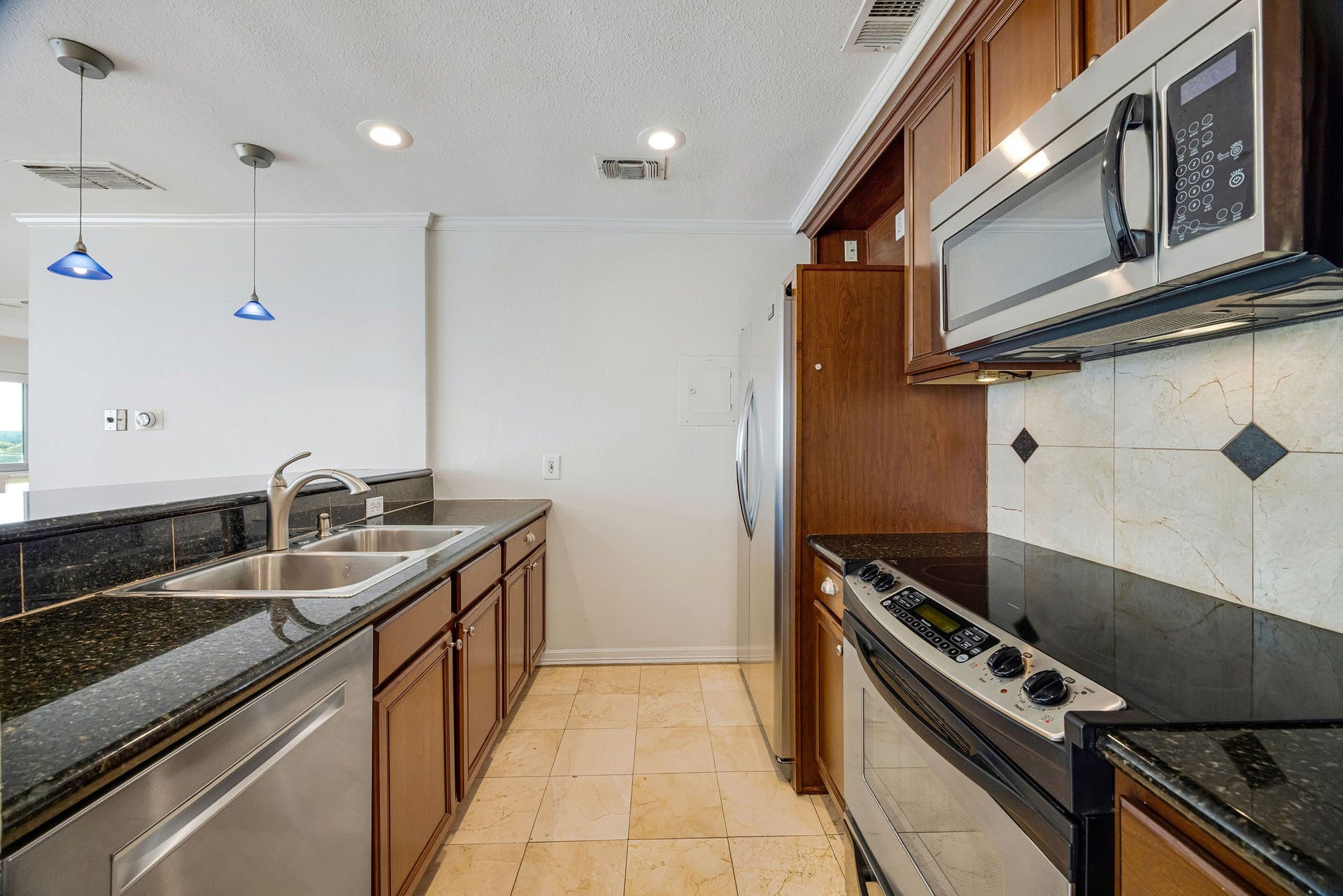 3600 Montrose Boulevard, #501, Houston, TX 77006 Modern kitchen with sleek stainless steel appliances, granite countertops, and elegant tile backsplash, offering a perfect blend of style and functionality.