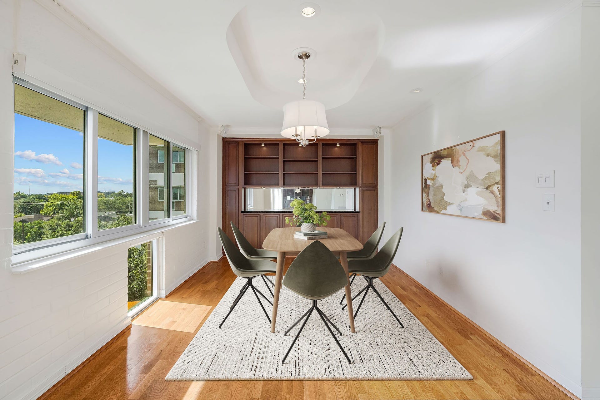 3600 Montrose Boulevard, #501, Houston, TX 77006 This virtually staged photo shows off a bright dining area with expansive windows, hardwood floors, and modern lighting perfect for entertaining.