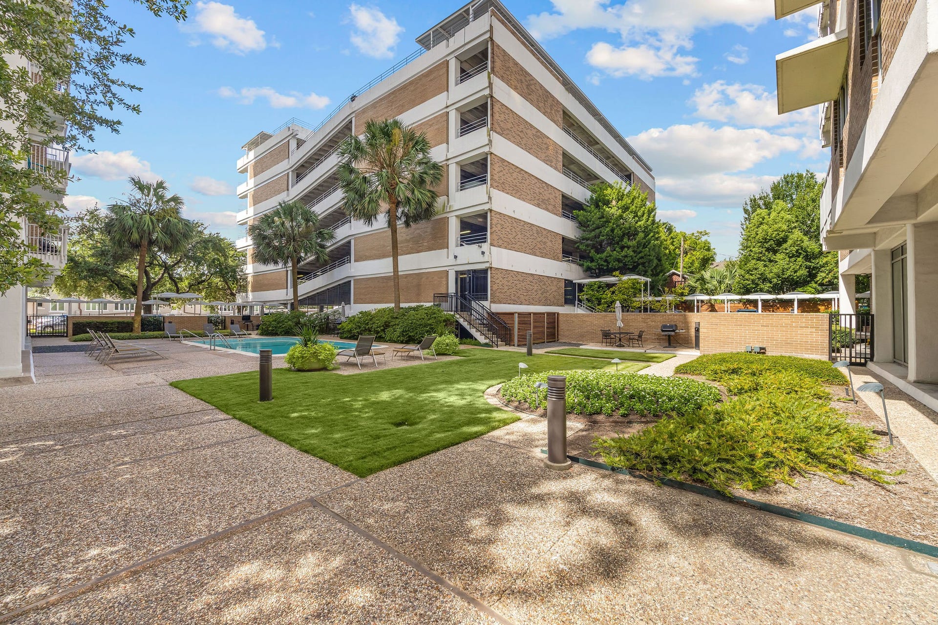 3600 Montrose Boulevard, #501, Houston, TX 77006 Beautifully landscaped courtyard featuring a sparkling pool, lush greenery, and ample lounging space.
