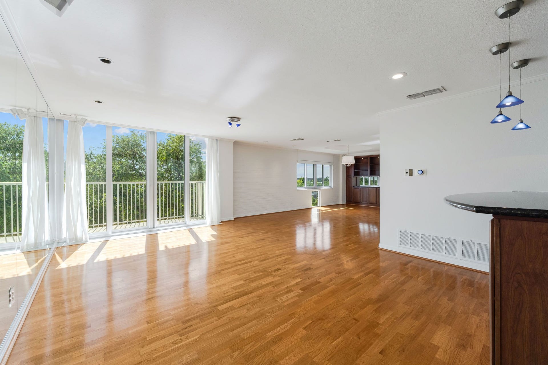 3600 Montrose Boulevard, #501, Houston, TX 77006 Spacious open-plan living area with hardwood floors, abundant natural light from large windows, and modern pendant lighting.
