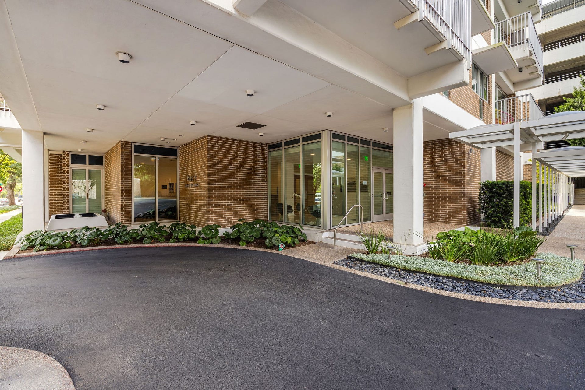 3600 Montrose Boulevard, #501, Houston, TX 77006 The building entrance has a covered driveway, sleek glass doors, and well-maintained landscaping, offering both style and convenience.