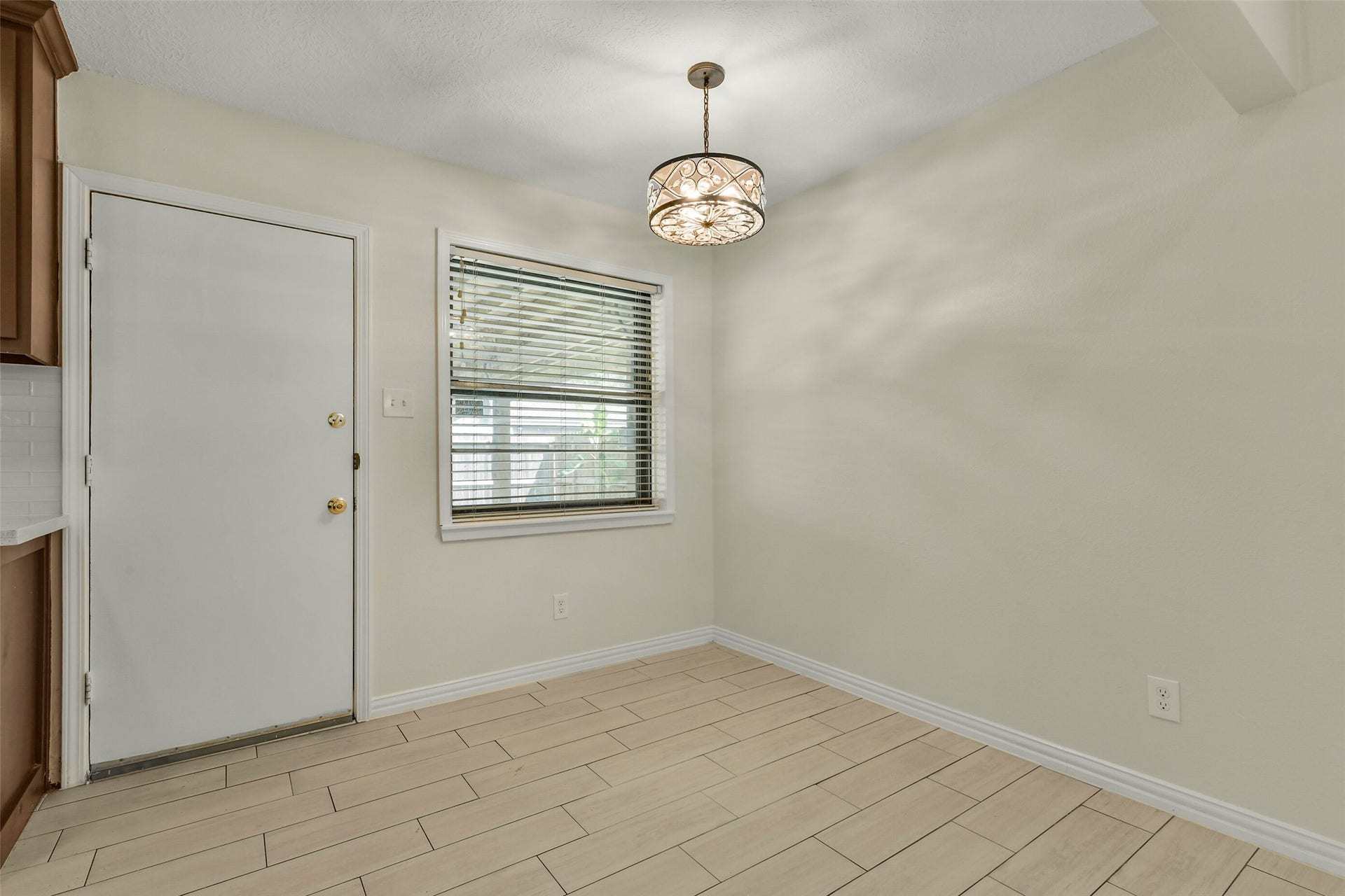 5003 Colombia Drive, Pasadena, TX 77505 Dining nook features elegant tile flooring, a modern light fixture, and ample natural light from a large window, perfect for cozy meals.
