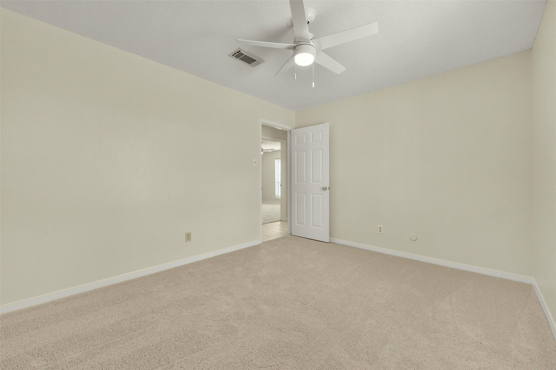 5003 Colombia Drive, Pasadena, TX 77505 Bright and airy bedroom featuring soft carpeting, neutral walls, and a ceiling fan, providing a comfortable and inviting atmosphere.