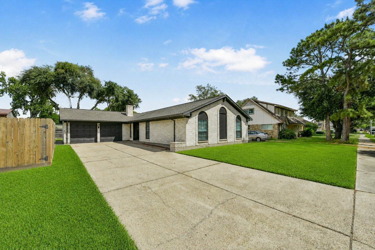 5003 Colombia Drive, Pasadena, TX 77505 Single-story home with a spacious driveway, elegant arched windows, and a beautifully manicured lawn, nestled in a serene neighborhood.