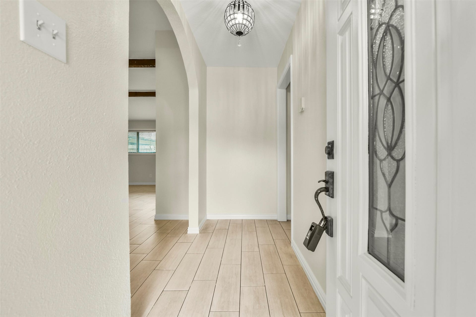 5003 Colombia Drive, Pasadena, TX 77505 Inviting entryway with elegant tile flooring, arched doorway, and a stylish hanging light fixture, leading to a bright and open living area.