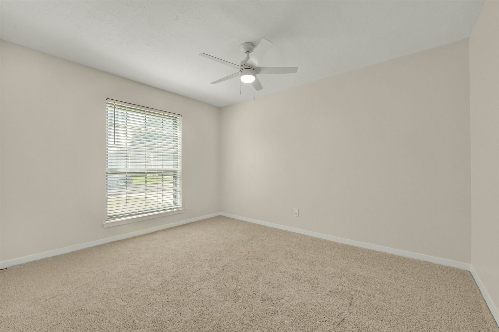 5003 Colombia Drive, Pasadena, TX 77505 Bedroom featuring neutral walls, plush carpeting, and a ceiling fan, complemented by a large window that allows natural light to pour in.
