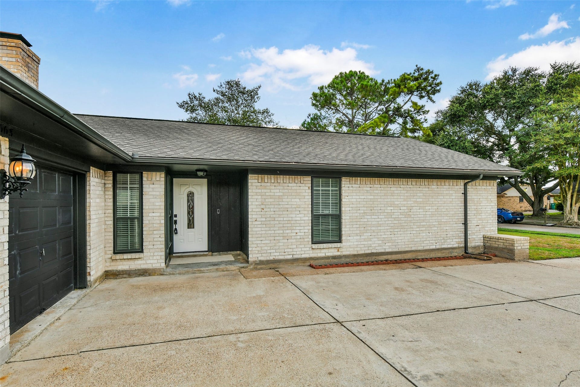 5003 Colombia Drive, Pasadena, TX 77505 Brick home with a spacious driveway leading to a two-car garage, featuring a welcoming front entrance and a well-maintained exterior.