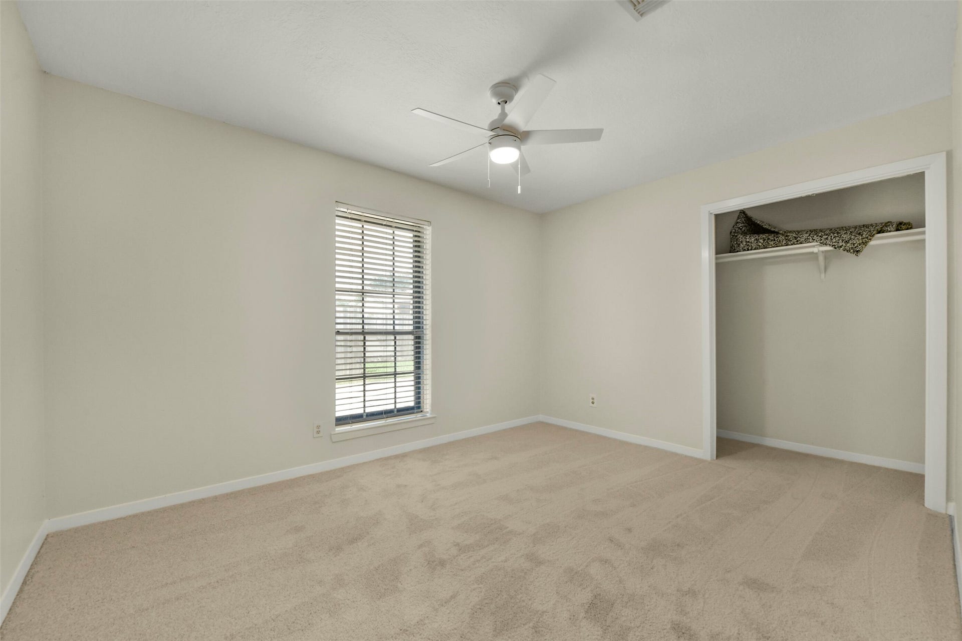 5003 Colombia Drive, Pasadena, TX 77505 Bedroom featuring soft carpet, a ceiling fan, and a large window for natural light, alongside a convenient open closet.