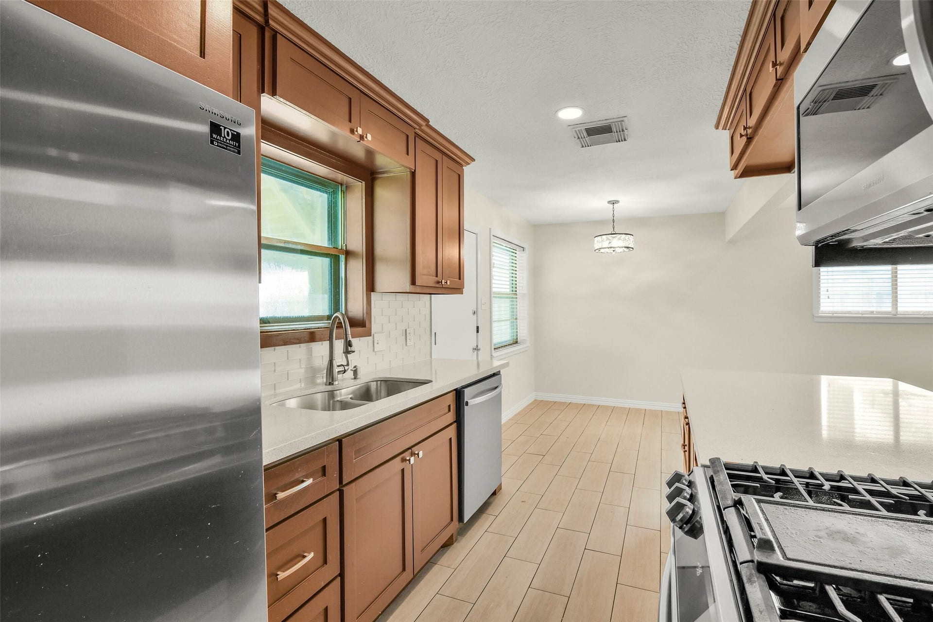 5003 Colombia Drive, Pasadena, TX 77505 Modern kitchen with sleek stainless steel appliances, warm wood cabinetry, and a spacious layout perfect for cooking and dining.