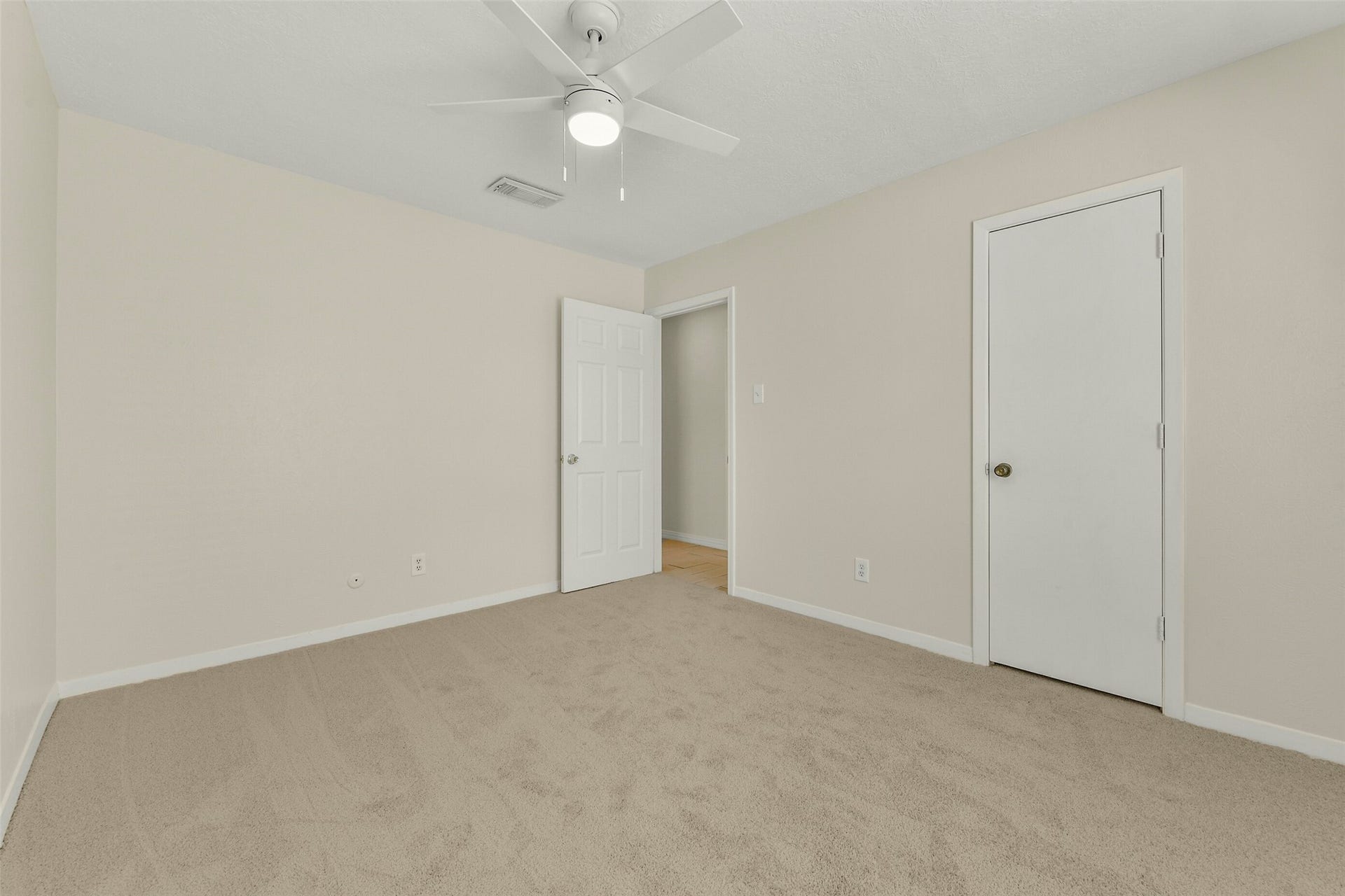 5003 Colombia Drive, Pasadena, TX 77505 Bright and inviting, this bedroom features neutral walls, plush carpeting, and a ceiling fan, offering a comfortable and serene space.