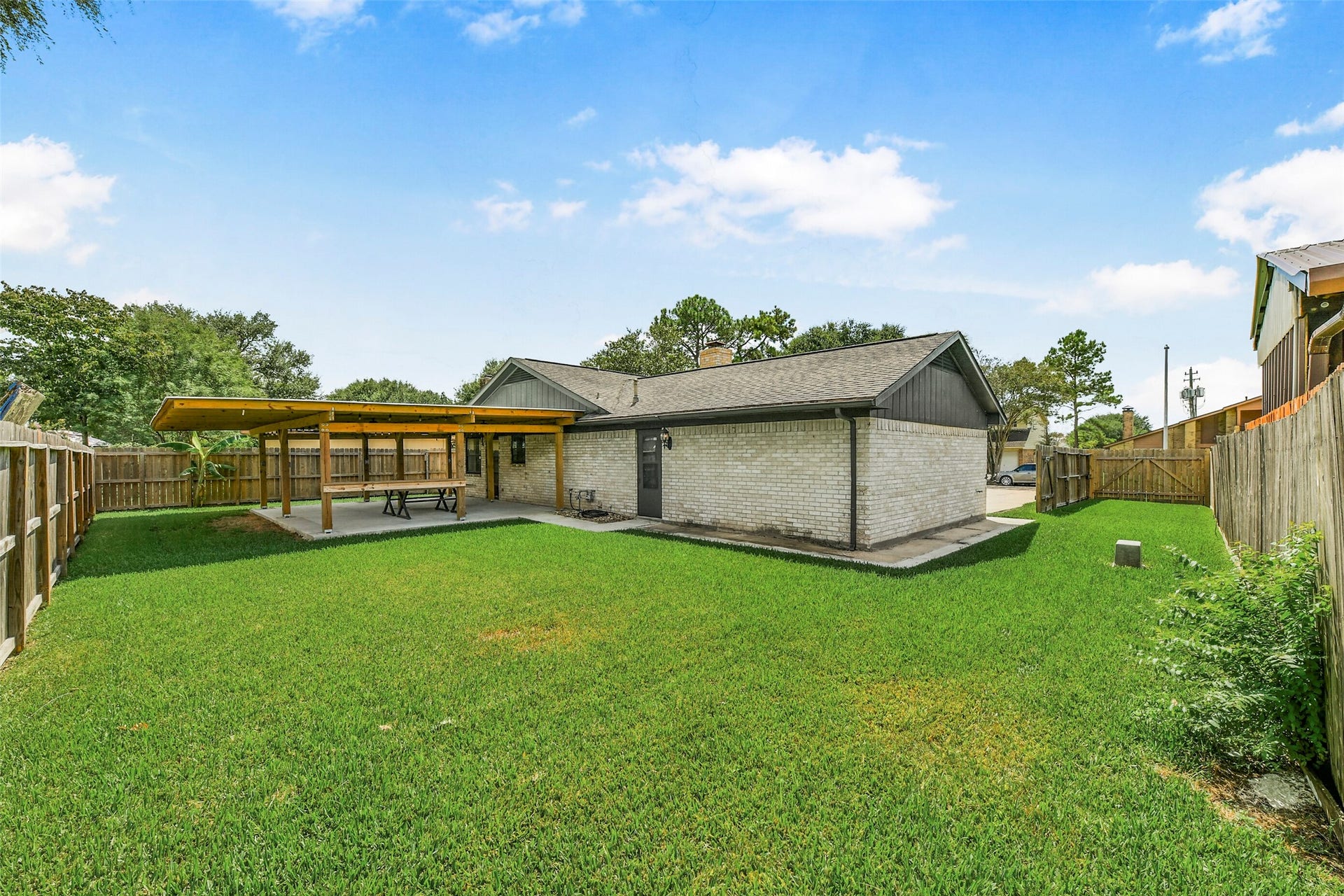 5003 Colombia Drive, Pasadena, TX 77505 Spacious backyard featuring a covered patio area perfect for outdoor dining and entertainment, surrounded by a privacy fence.