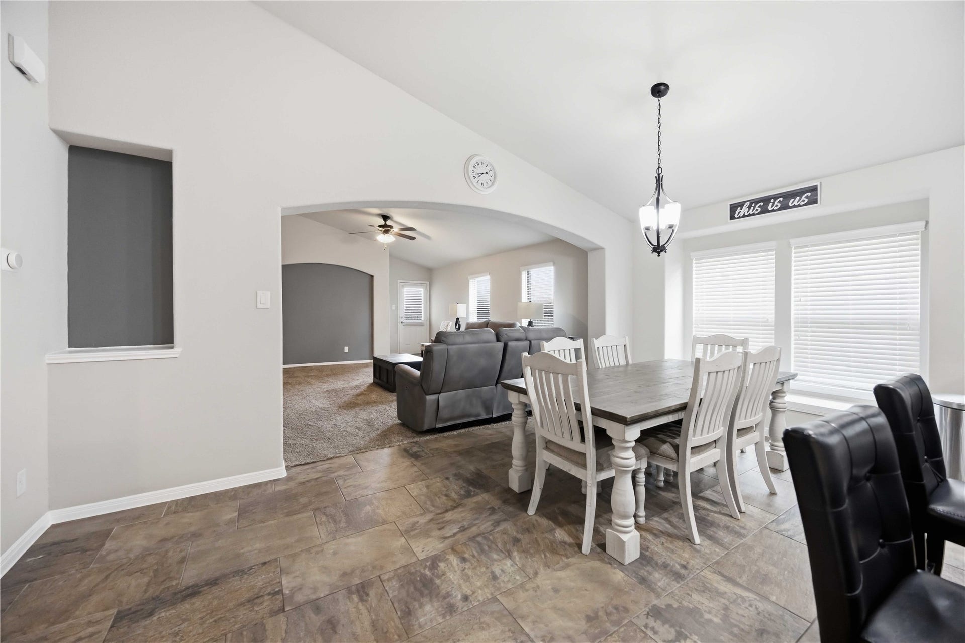 712 Rim Water Drive, Alvin, TX 77511 Bright and inviting open-concept living area featuring a cozy dining space with natural light, seamlessly flowing into a comfortable lounge area with plush seating and neutral tones.