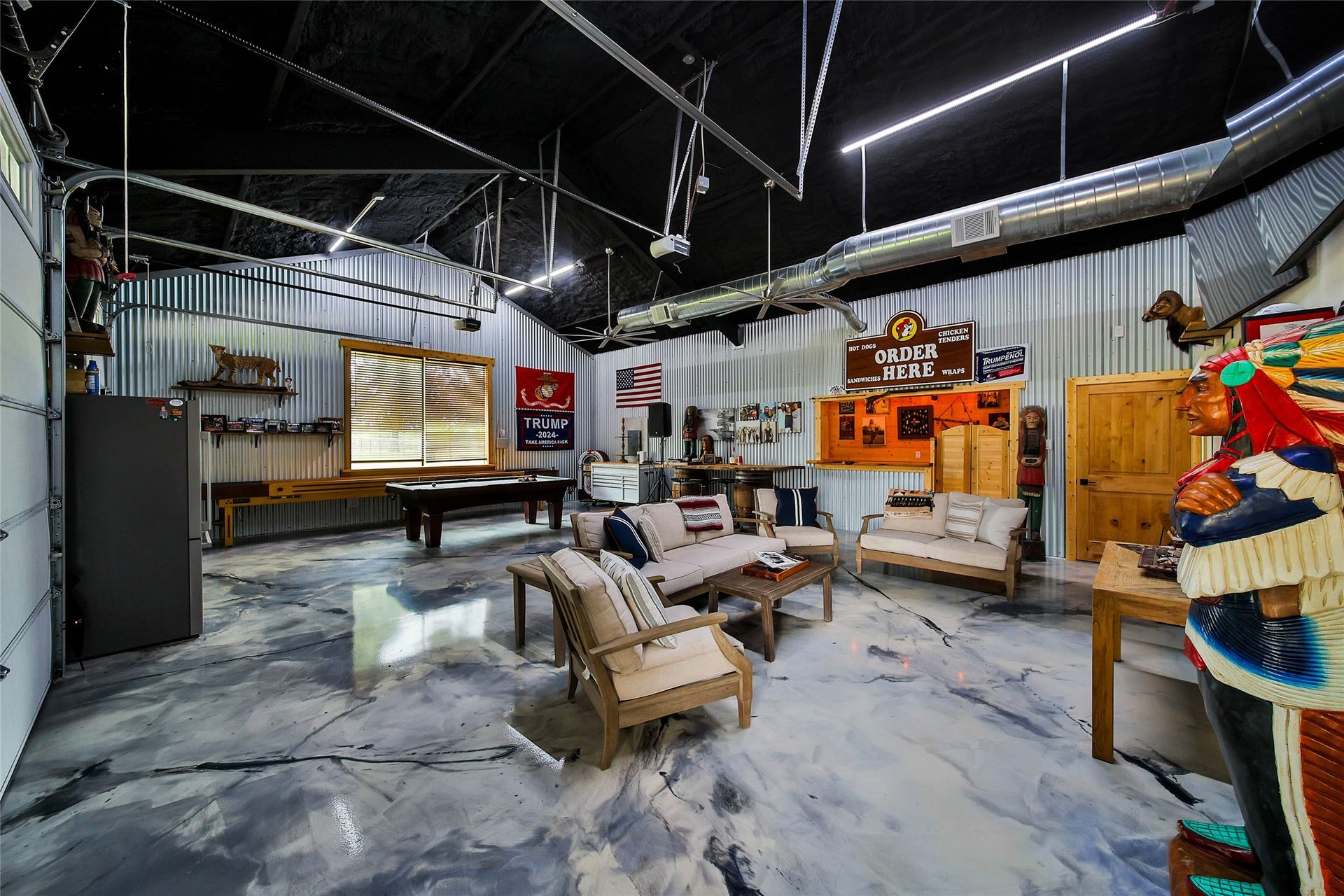 1,050 sq. ft. fully insulated party barn featuring stunning epoxy swirl floors, central AC/Heat, custom bar, half bath, soaring ceilings, LED lighting and abundant space for entertaining, games or gatherings.