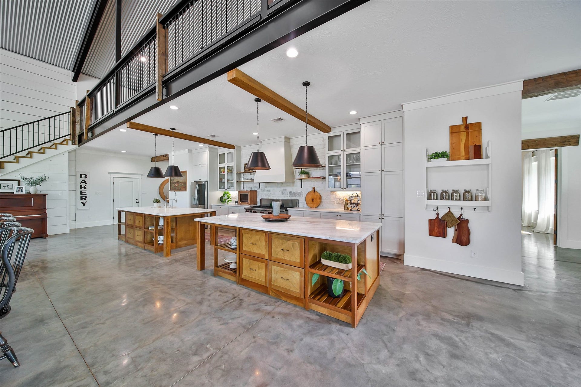 Chef-inspired kitchen showcases exposed wood beams, custom cabinetry, dual oversized islands, an expansive walk-in pantry, and abundant storagedesigned to combine exceptional style with everyday functionality.