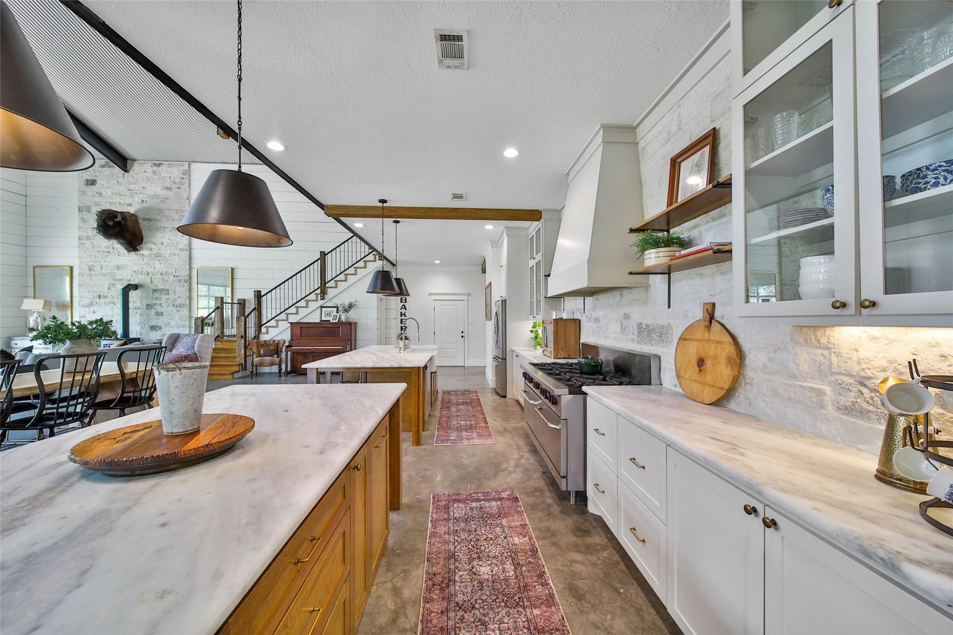 Entertainer's kitchen with double dishwashers, commercial 10 burner double oven range, two islands, Shadow storm granite countertops, custom stone backsplash and additional countertop workspace and storage.