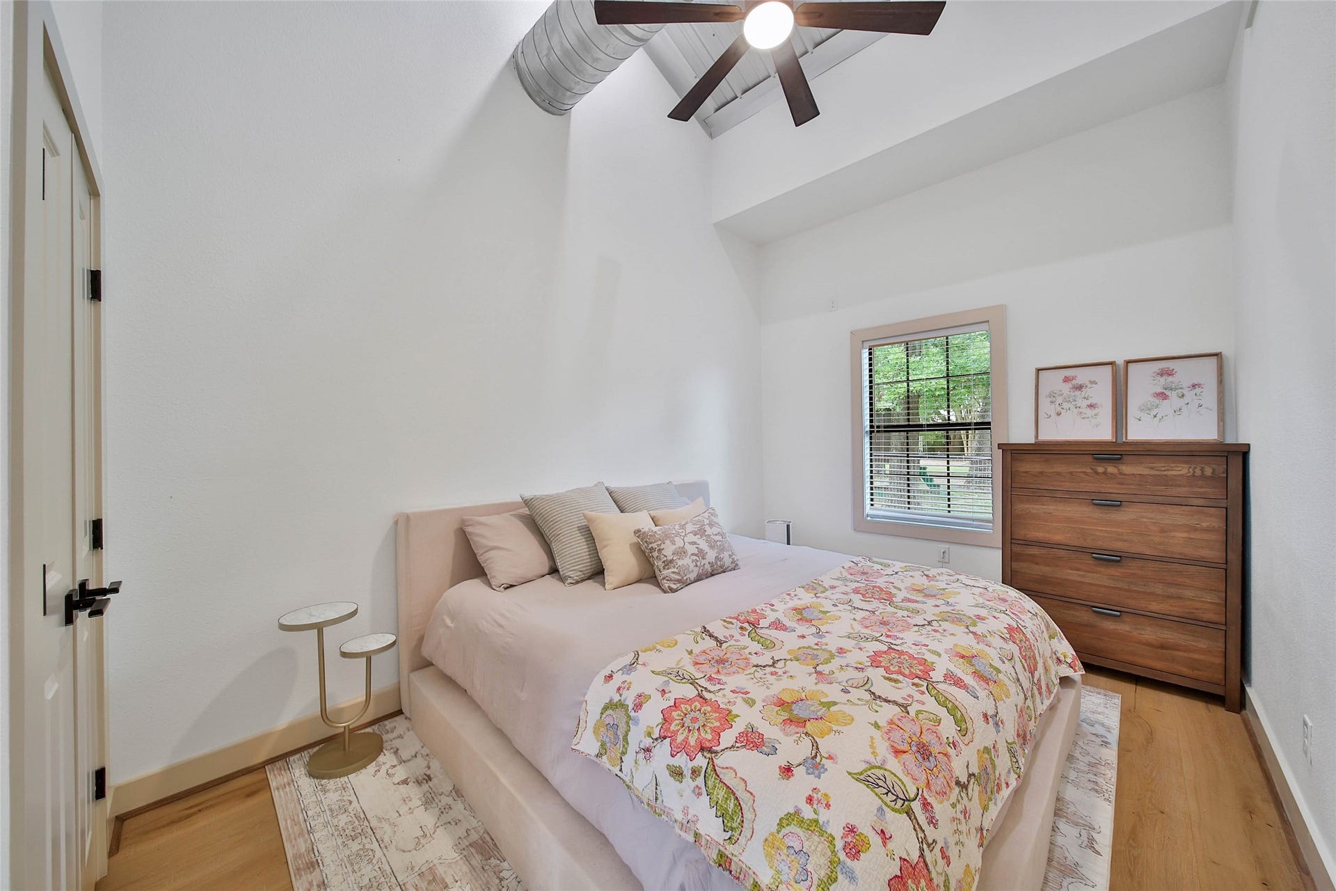Private garage apartment bedroom features soaring metal ceilings, hardwood floors, abundant natural light and a peaceful retreat for guests or extended family.